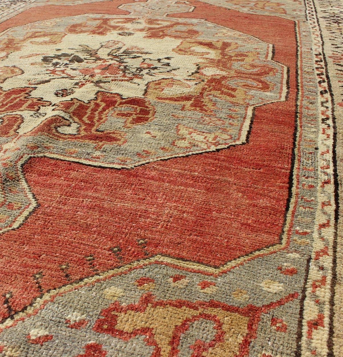 Mid-20th Century Faded Red and Taupe Vintage Turkish Oushak Rug with Layered Medallion Design For Sale