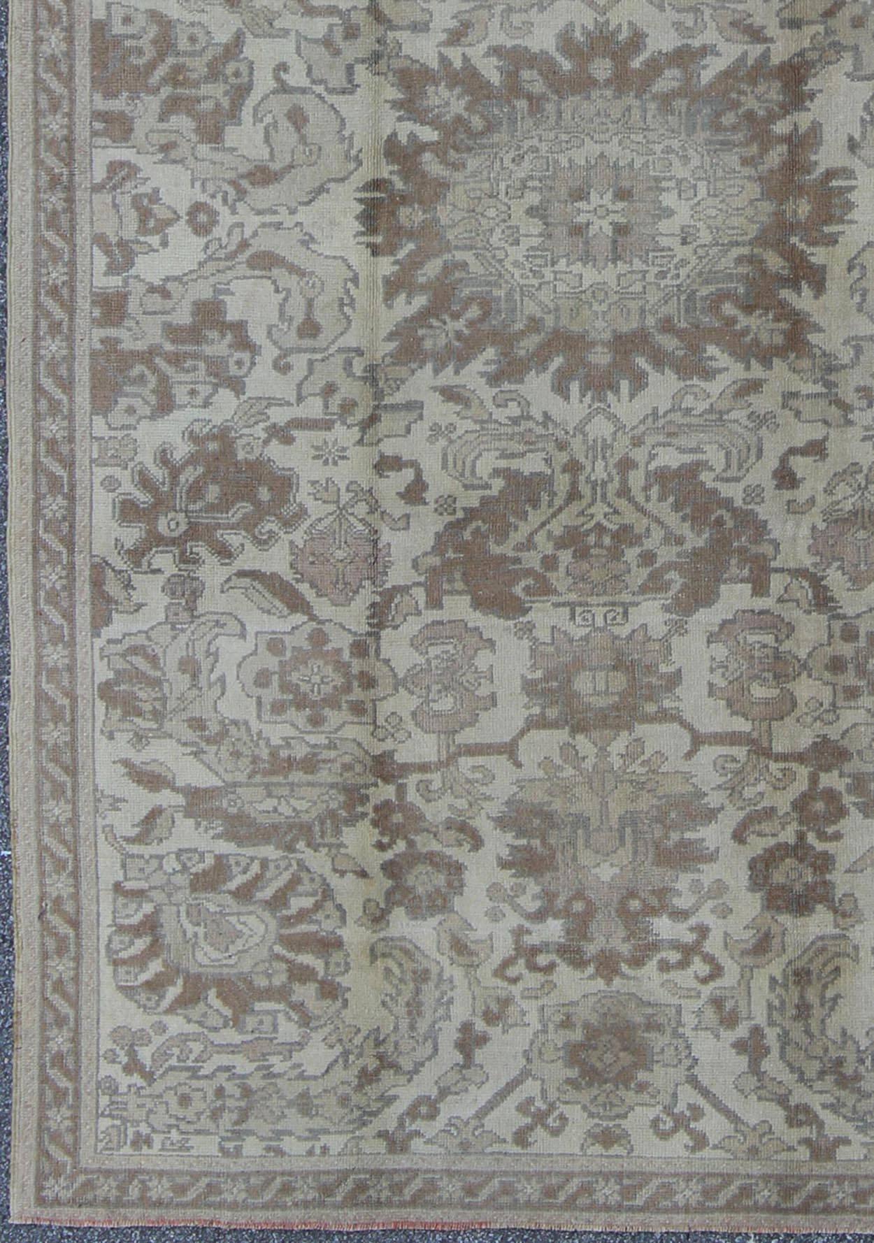 All-over blossoming floral design rug in brown, taupe, and ivory, rug tu-ugu-3400, country of origin / type: Turkey / Oushak, circa 1940

This vintage Turkish Oushak carpet (circa 1940) features a central blossoming flower surrounded with smaller,