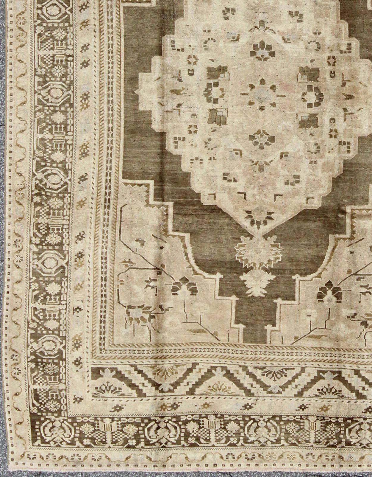Medallion geometric tribal design Oushak rug vintage from Turkey, rug tu-ugu-95066, country of origin / type: Turkey / Oushak, circa 1940

This striking Turkish Oushak rug bears a rich mocha colored body that is highlighted by a dazzling linear