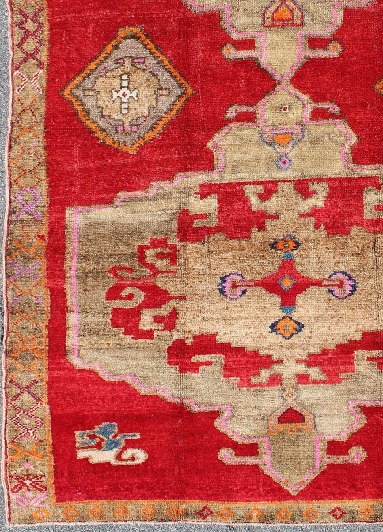 Measures: 5'11'' x 10'4''.
This Turkish rug features a dual central medallion design as well as patterns of smaller Sub-geometric elements in the border. Colors include various shades of red, blue, ivory, taupe and pink. Turkish Oushak are notable