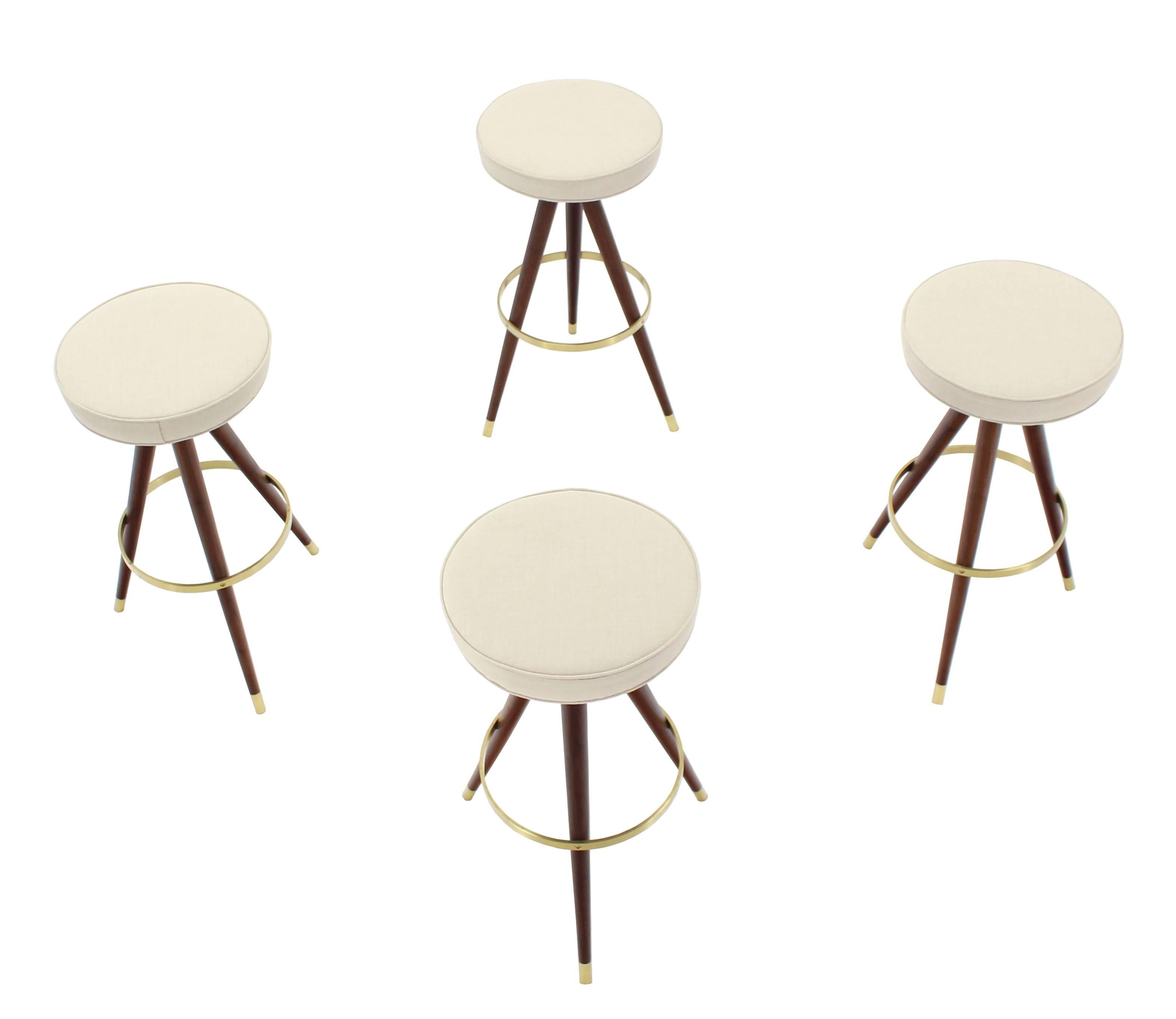 Set of four Mid-Century Modern walnut bar stools with solid brass ring stretcher, new upholstery.