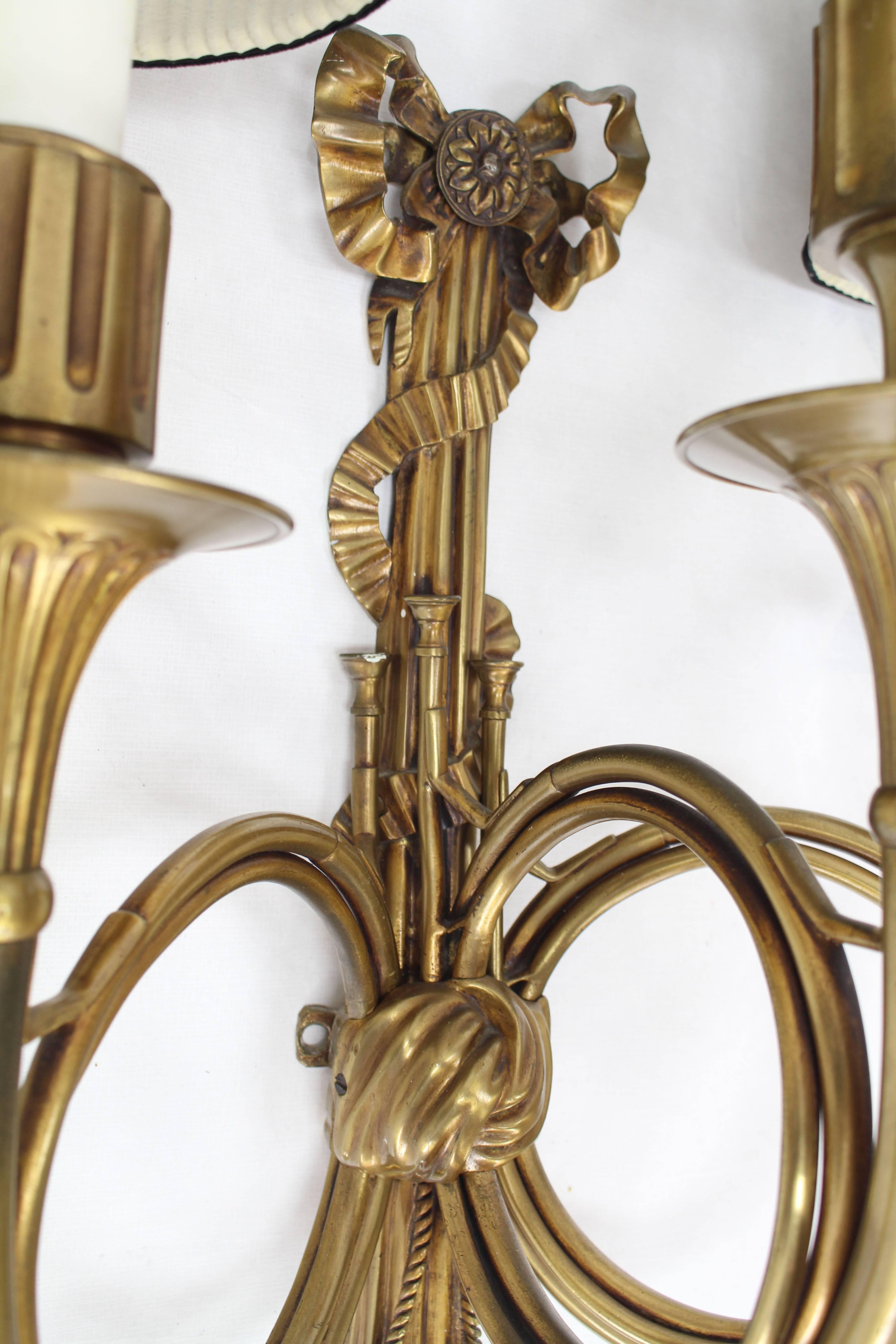 Beautiful French bronze sconce with elements of horn, tassel and ribbon.
This is a nice and heavy fixture with three lights and original shades.