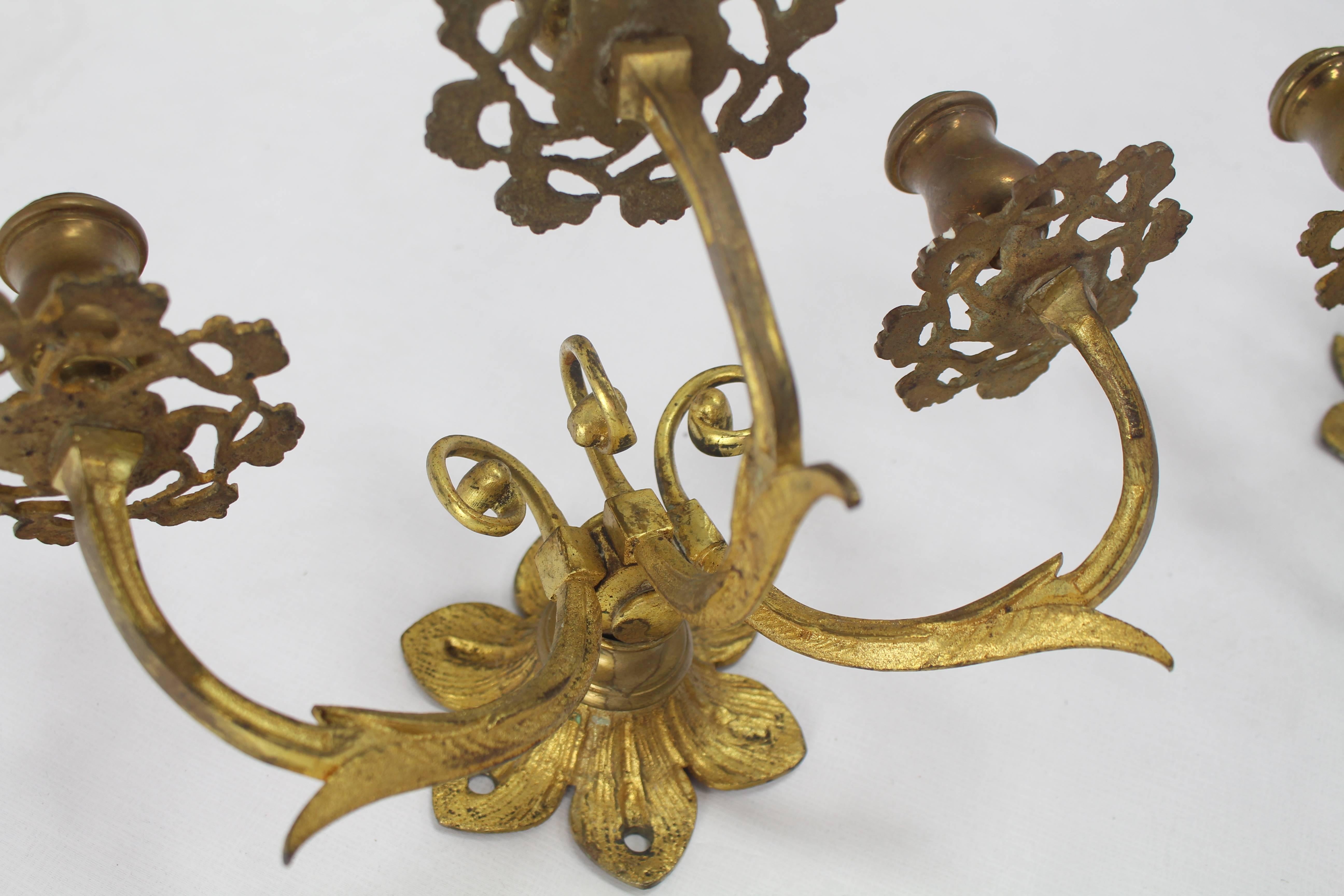 Pair of French brass three arm gold gilt sconces.