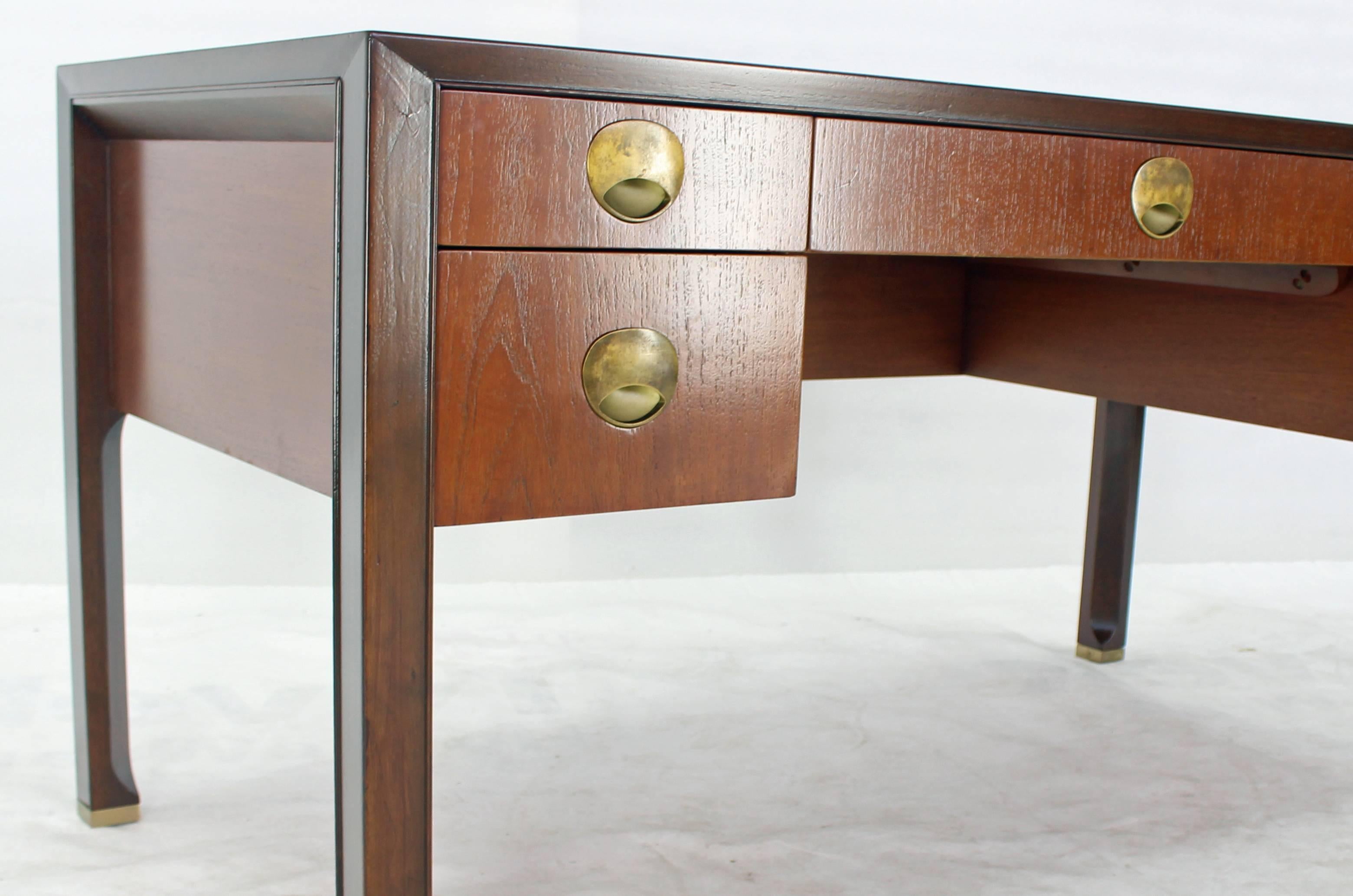 Mid-Century Modern teak walnut case leather top executive desk with brass pulls. Heavy solid brass feet tips. This is possibly Finn Juhl design desk.
       