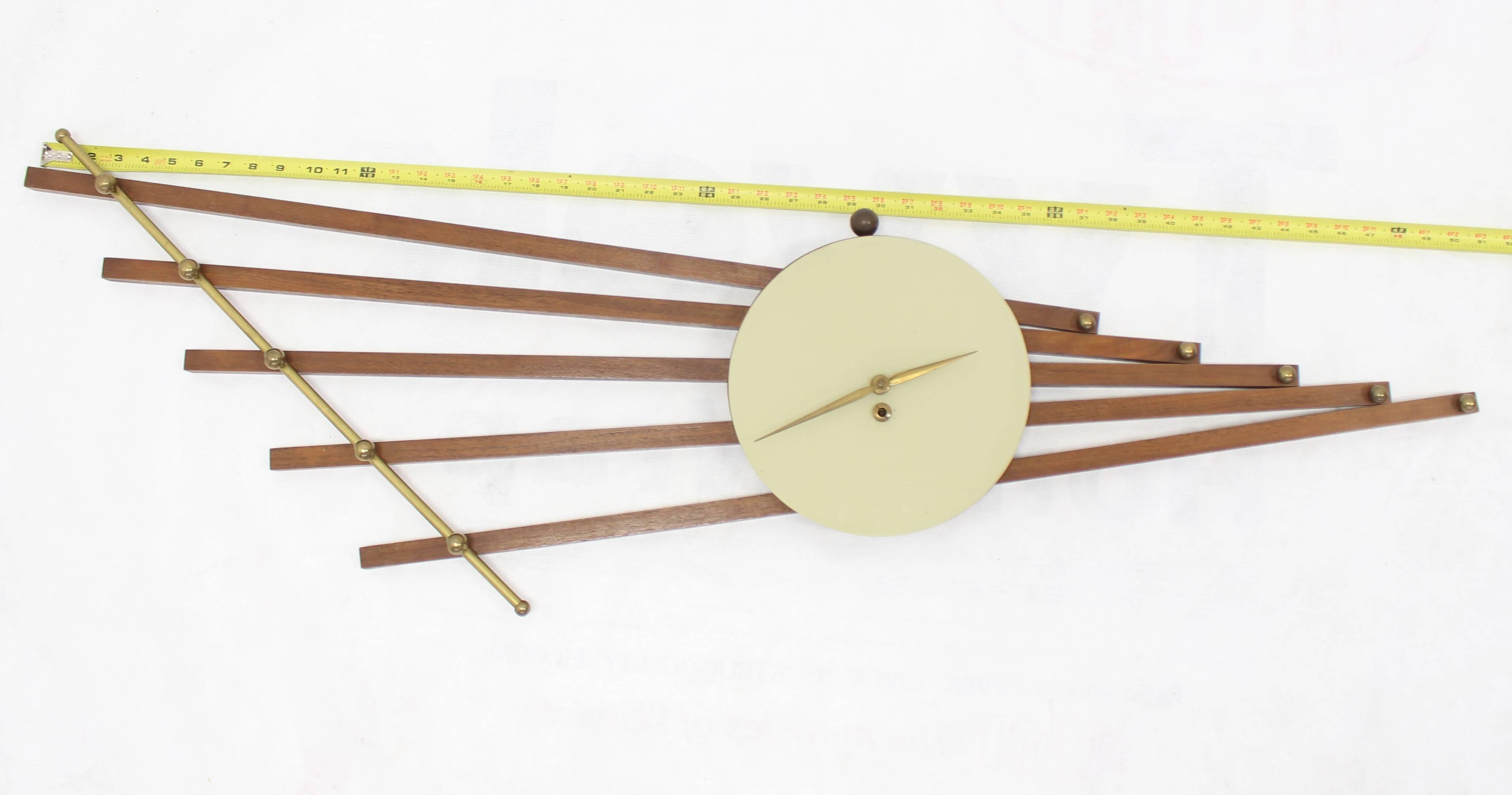 Mid-Century Modern French Deco style wall clock sculpture. Nice combination of solid brass and walnut details. Dated 1959, stamped: Made in France.
 