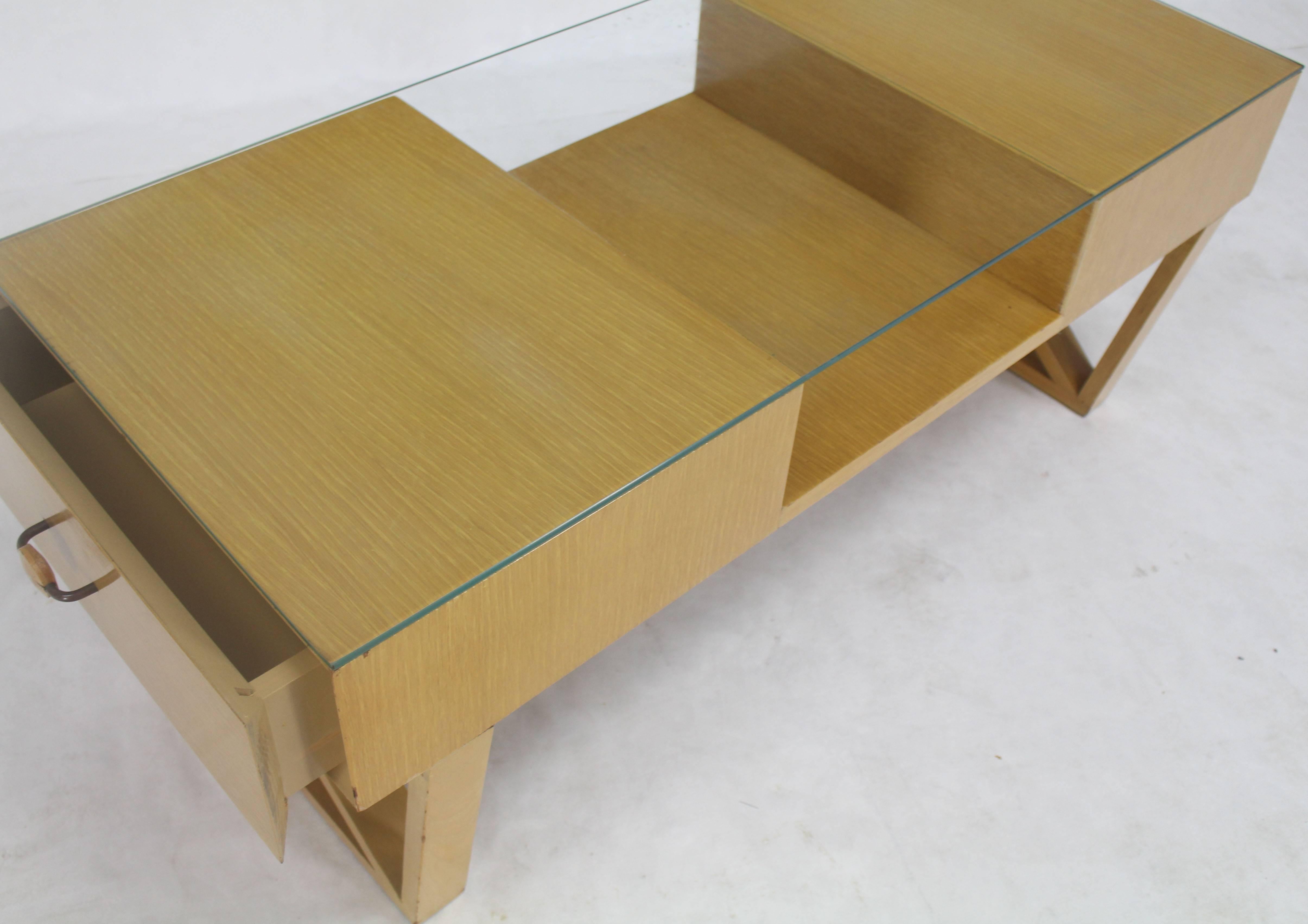 Mid-Century Modern circa 1950 glass top X-base coffee table with shelf and two-drawer storage compartments. Excellent vintage condition.