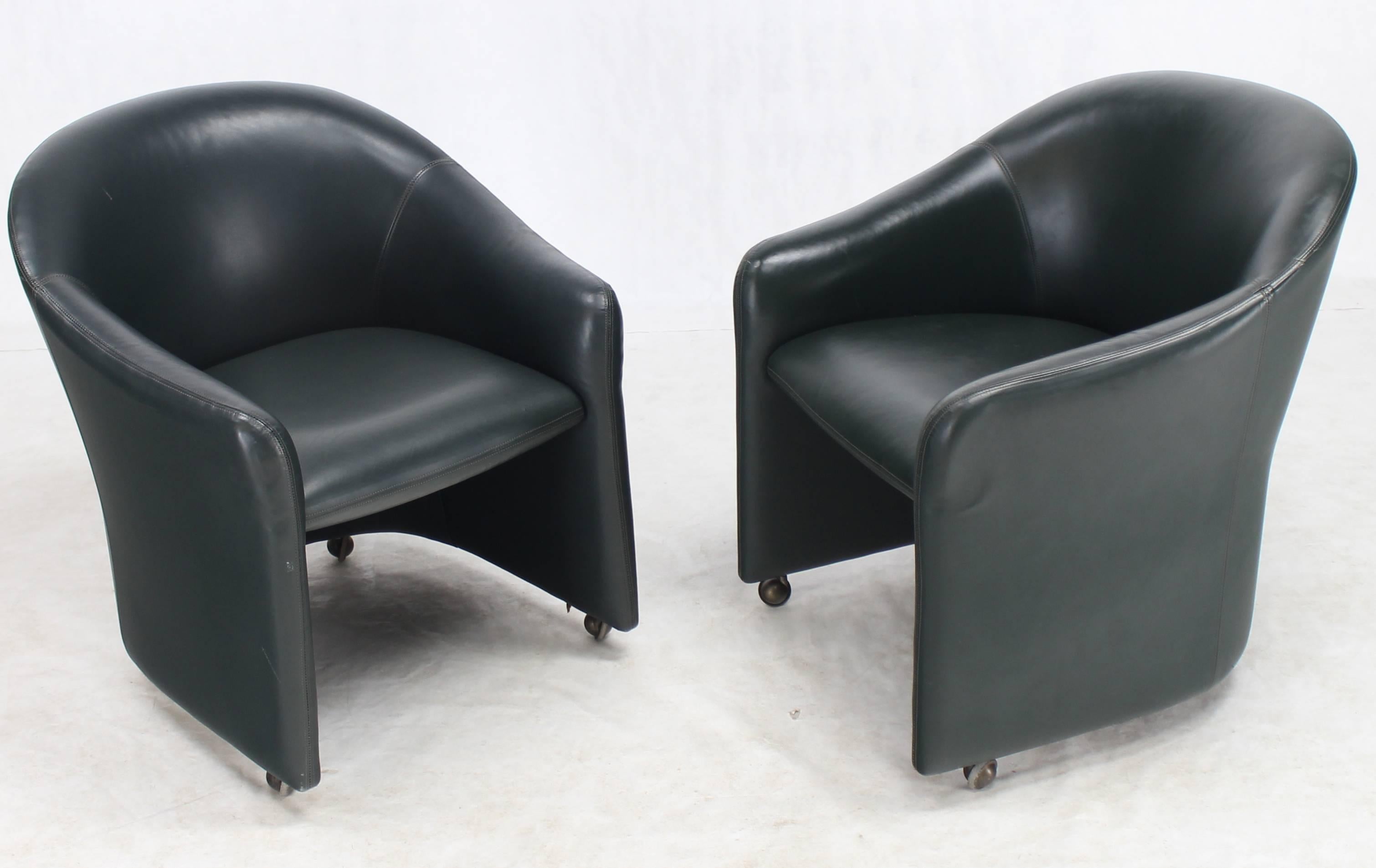 Mid-Century Modern olive leather upholstery set of four barrel back swivel chairs.