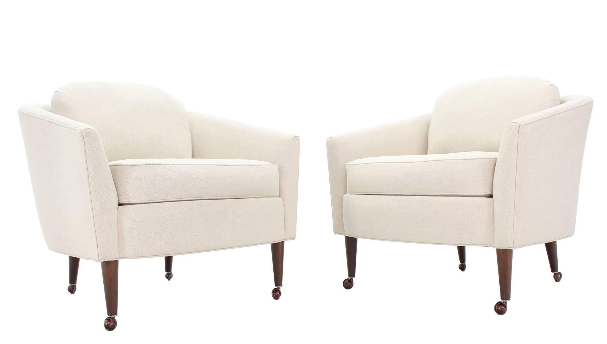 Pair of newly upholstered Mid-Century Modern barrel back chairs on oiled walnut legs.