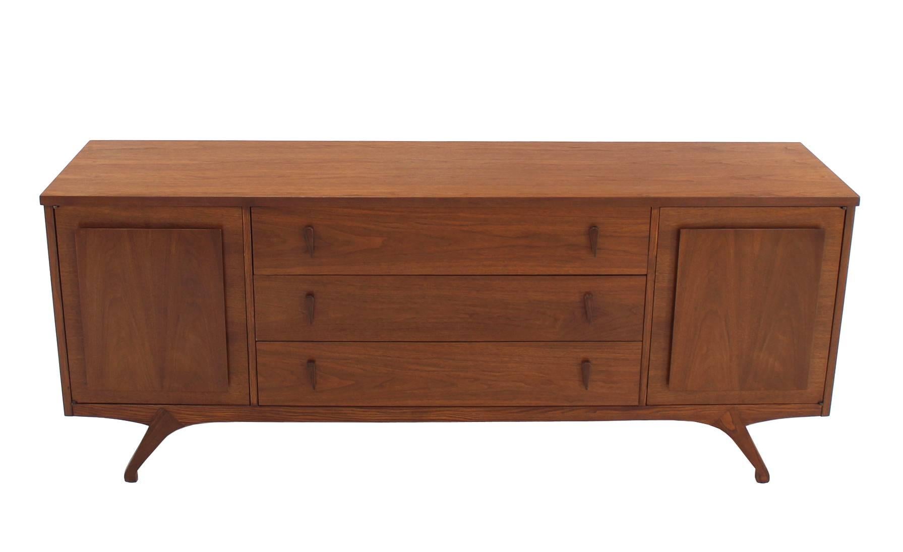 Bellissimo comò lungo in noce di stile Mid-Century Modern con gambe scolpite e tiranti in noce massiccio.