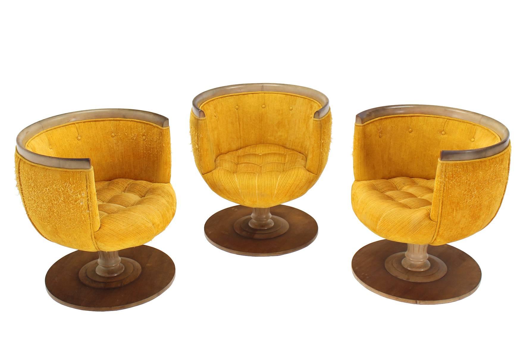 Set of three very nice barrel back revolving chairs sitting on round wooden bases. These are rare outstanding design chairs in good structural condition needing new upholstery.