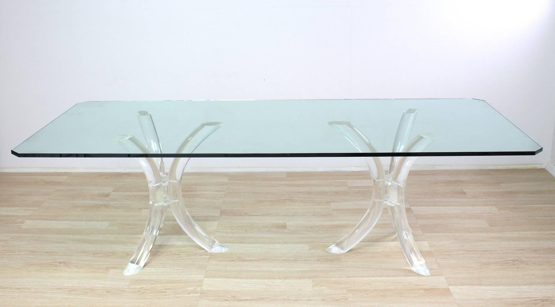 Very nice Mid-Century Modern dining or conference table. The thick 3/4" glass top sitting on two heavy lucite tusk tripod bases.