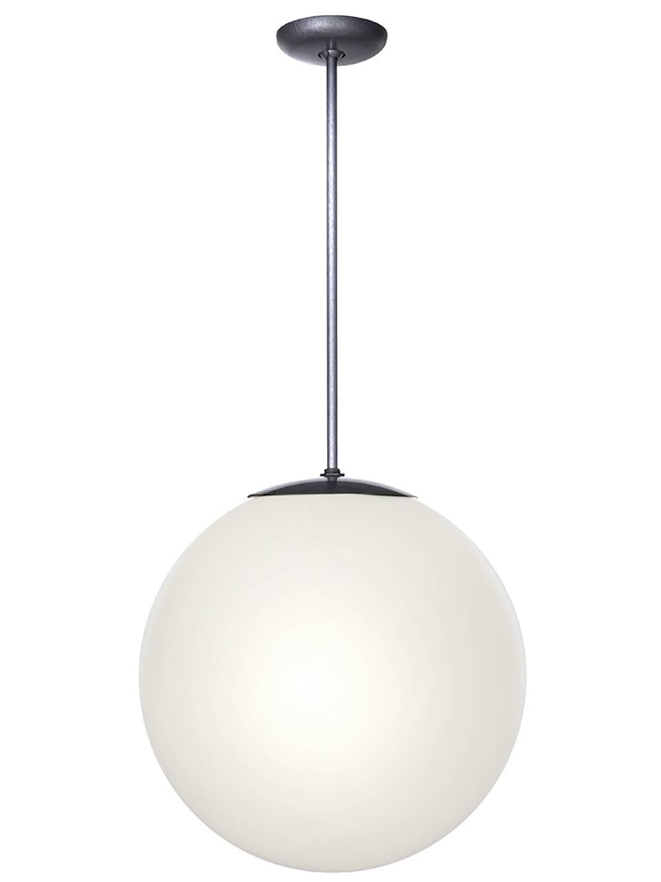 These late 1950s full moon milk glass globe lamps were a favorite of architects and designers of the period. They have a simple, clean and elegant design that have made them a Mid-Century Modern icon. We have a nice collection of these fixtures in