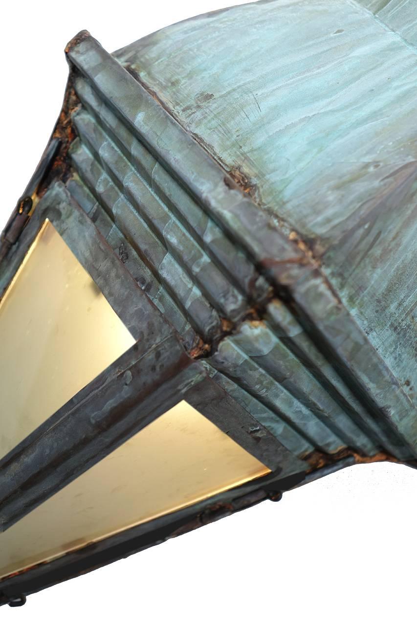 The beautiful wedge shape sconces have a bit of an Arts & Crafts or Frank Lloyd Wright look. The all copper handcrafted sconces are finished in a weathered verdigris green. The two lit panels are milk glass. These impressive 36 inch tall lamps are