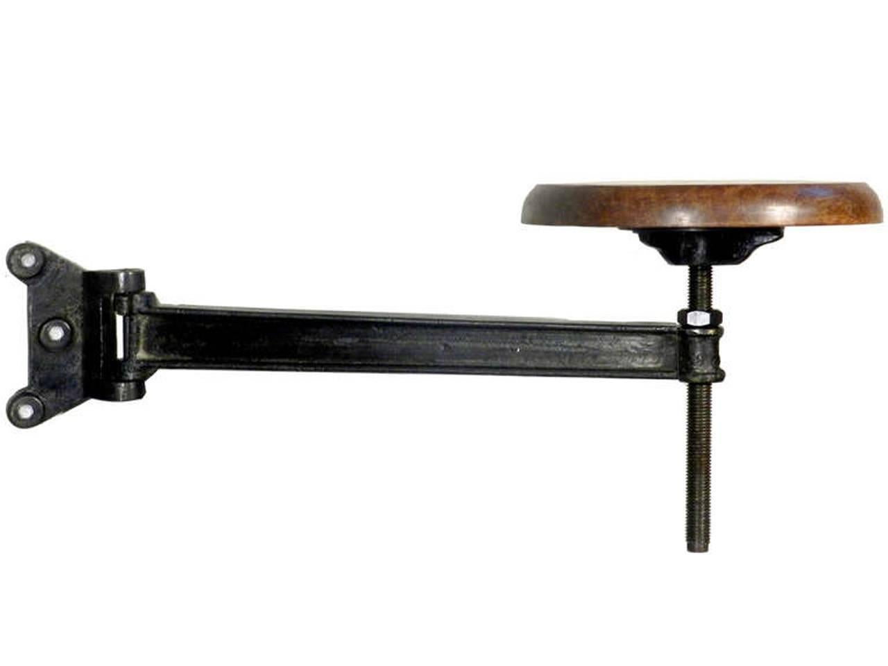 These stools are very well made with a thick solid wood seat and a 1 inch thick cast iron arm. At the turn-of-the-century these benches were found attached to machine and wood working tables. They were very practical for a busy factory setting. When