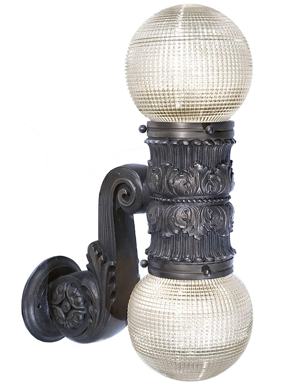 These lamps are by Dankmar Adler and Louis Sullivan.
The bronze castings are ornate and heavy for their size. They must have been salvaged from an important and detailed building. The 6 inch shades are prismatic glass in unique round shape. These