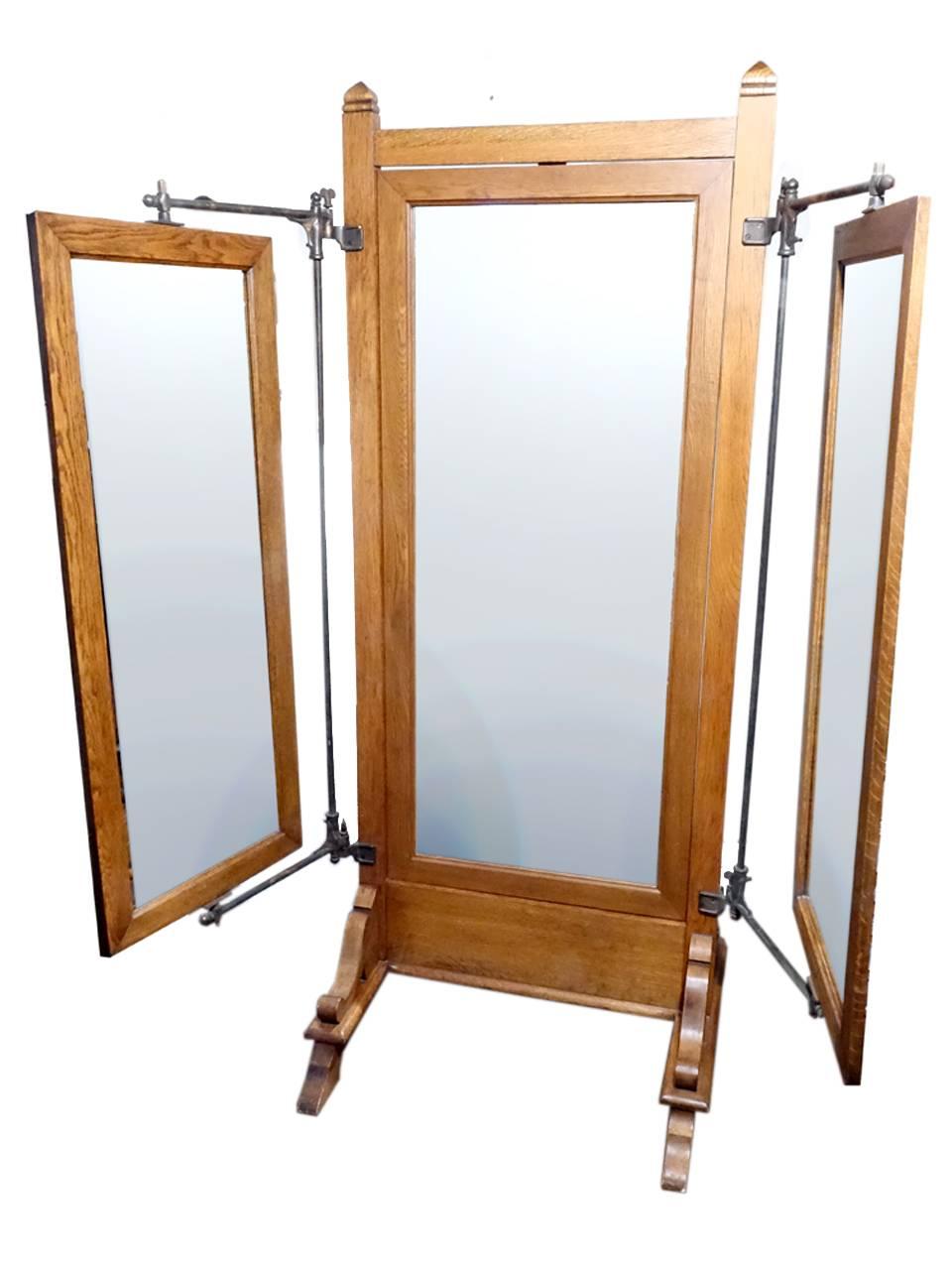 These early commercial mirrors are very hard to come by. I like them best when they have the ornate cast iron swivel outriggers. They look great and function even better. It has a handsome heavy Empire oak wood frame in it's original finish. The
