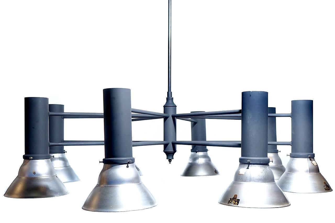 This is a large early industrial chandelier and has the look of an operating theater light. There are eight signed and matching mirrored mercury glass shades. They are 1915s to 1920s Permaflector from the Pittsburg Reflector Co. Each shade has an 8