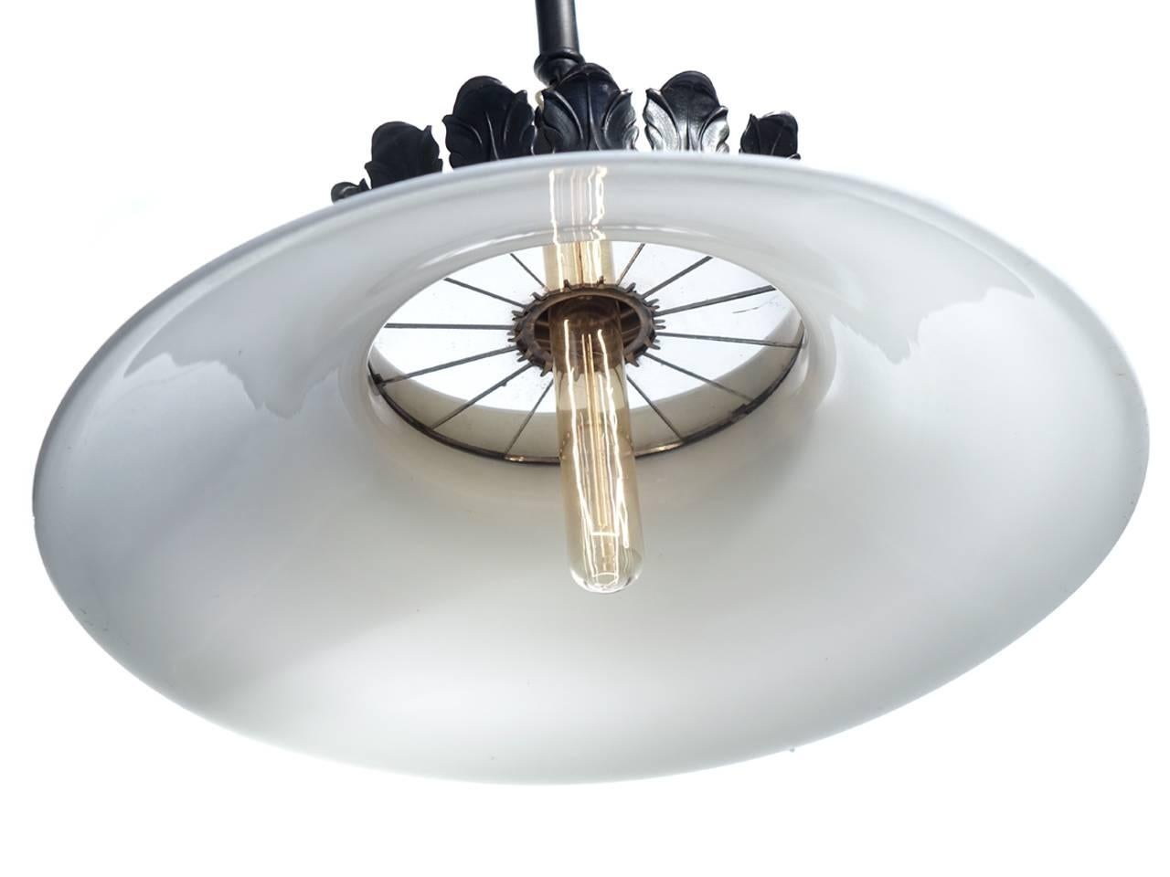 This is a very early lamp and most likely from the beginning of the electric lights. It's one of the first lamps that came after gas lighting. The milk glass shade is handblown and inside you can see the original 14 mirror reflector. This is