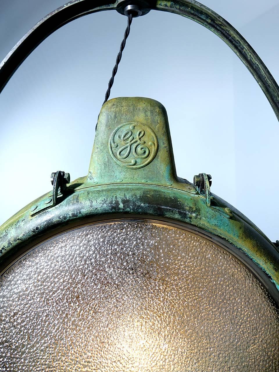 This is a rare and unique matching pair of Novalux Projectors by General Electric. This all copper light is original with an beautiful rustic patina. The large 15 inch pebble textured lens is in perfect condition, as is the huge mirrored mercury
