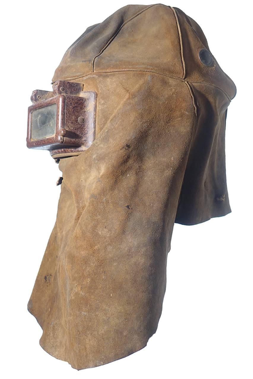 This is a nice small collection of unique Primitive and early safety helmets.
There is a welding mask, a painting or sand blasting mask with a connection for oxygen and possibly a Bee keepers mask. The bee keepers helmet on canvas with a tieback