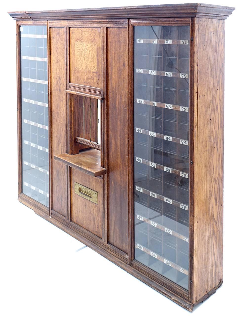 This is a beautiful early US post office window. It still has the original numbered slots to sort mail, the brass mail slot reads letters. It has the original gated window ant two doors to close it. Behind the mail slot is a draw to catch letters.