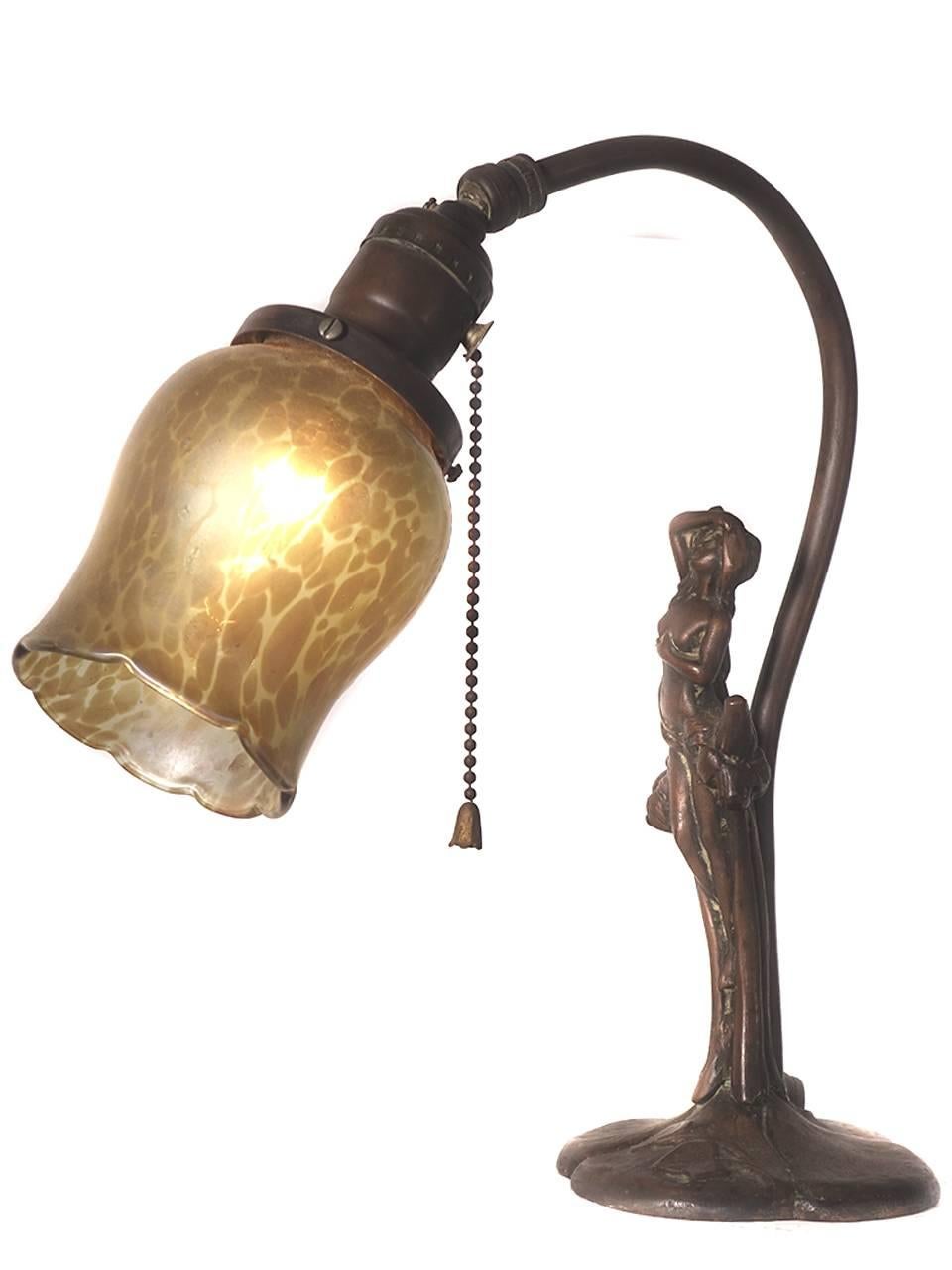 This Art Nouveau is a small gem. Its cast in bronze with a beautiful one of a kind handblown tortoiseshell patterned art glass shade.
