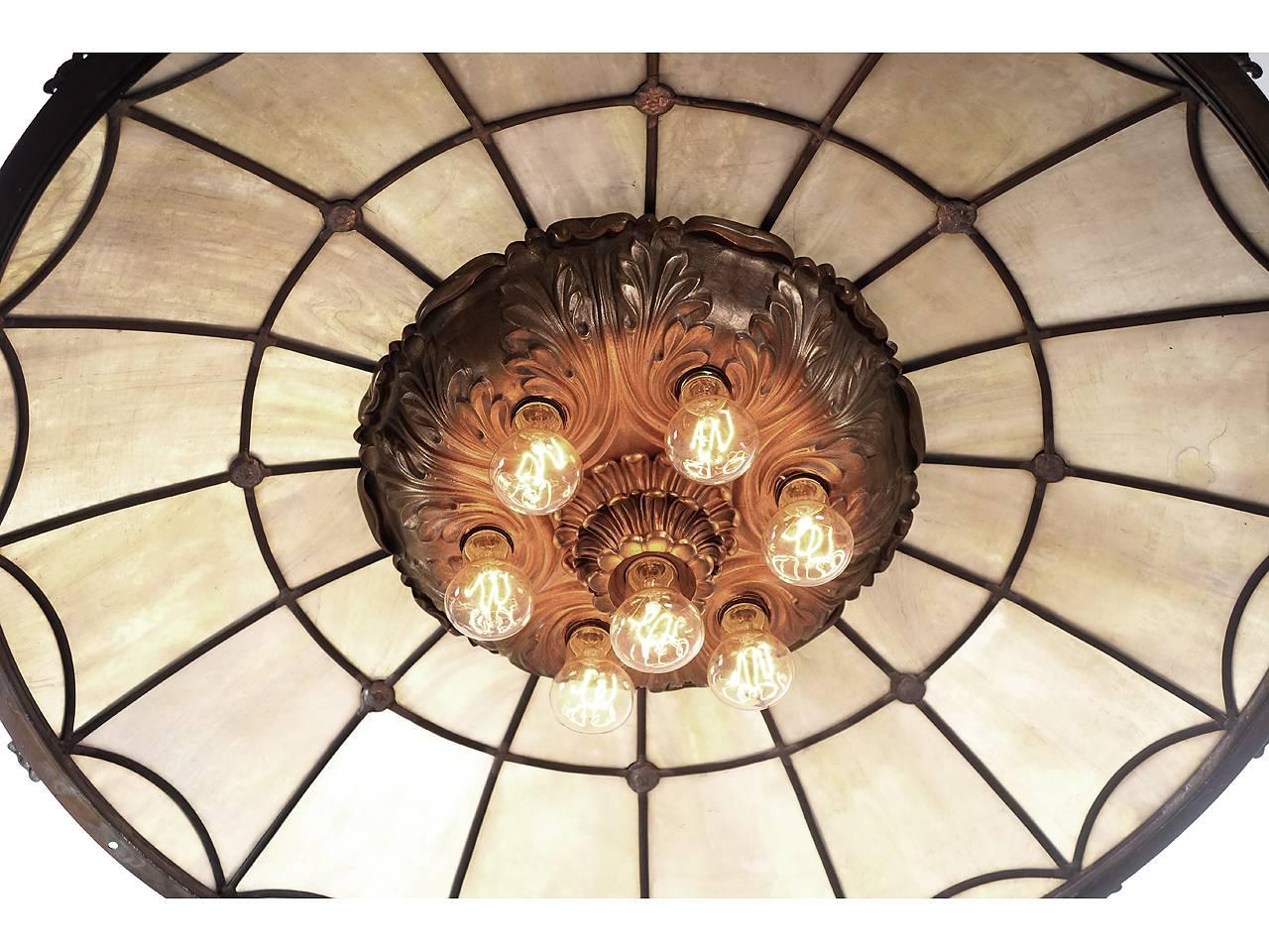 This is as elegant as it gets. The layered casting has seven bulbs and is heavy bronze. The skylight style domed shade is almost 3 foot in diameter with an cream/amber leaded glass and cast bronze details. The quality looks as if it was created by