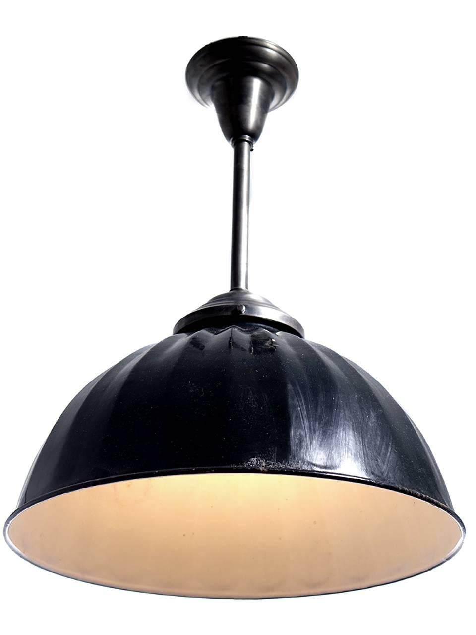 This is a nice large Industrial dome with a black over white finish. The hardware is a brushed silver finish. There is an interesting decorative pleated stamping all around the surface. The finish has a light rustic patina showing a few marks here