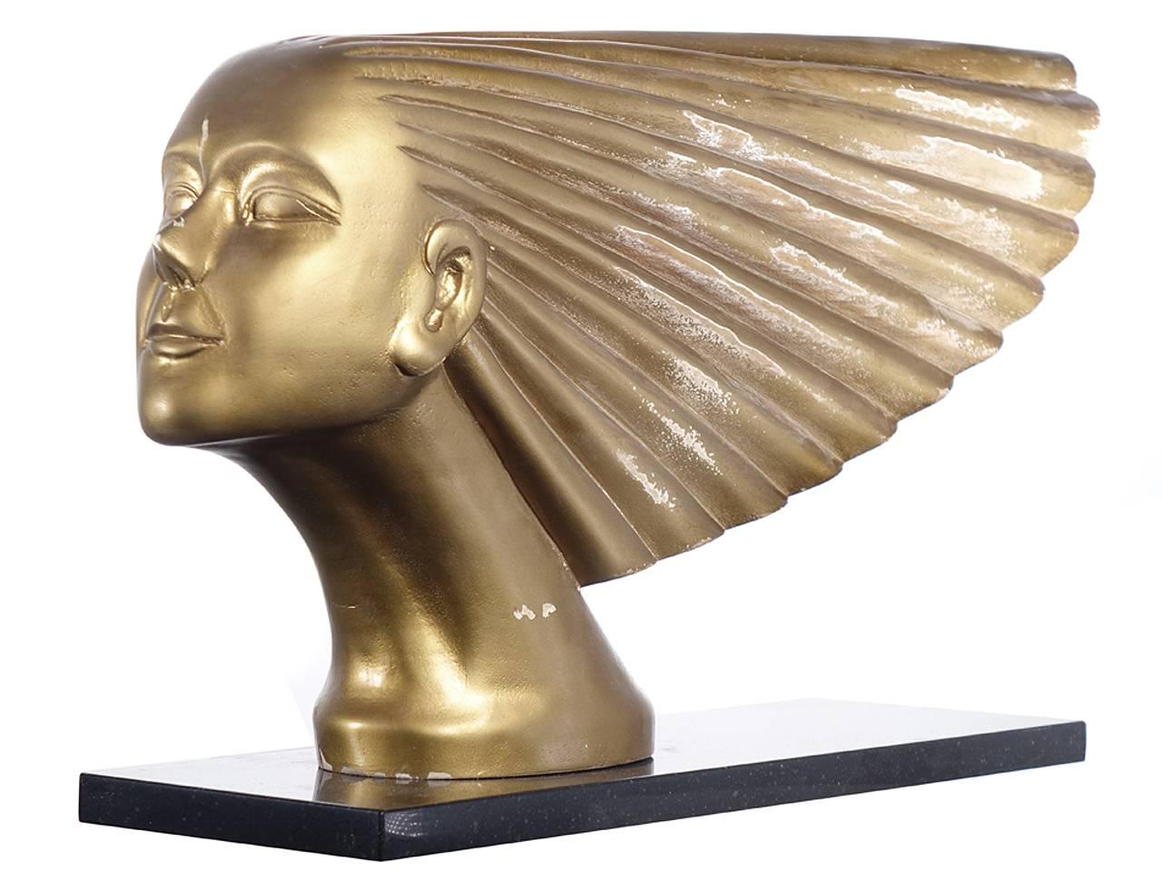 This is not a plaster, resin or plastic reproduction. This is a two foot long carved wood study for the Iconic Art Deco car mascot named Victoire. It has a gesso primer and a gold finish. There are warn areas that revel the wood. Its design was