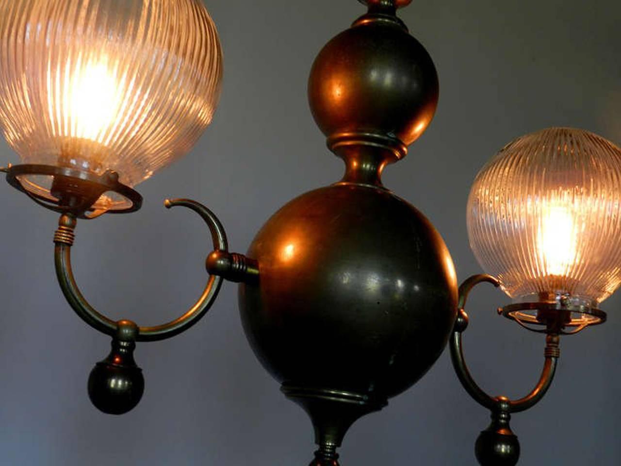 This lamp is a bit more traditional in style than what I normally offer. The repetitive spheres and holophane globes make this impressive double chandelier unique... I couldn't resist. Each prismatic globe is 8 inches and the total width is 28