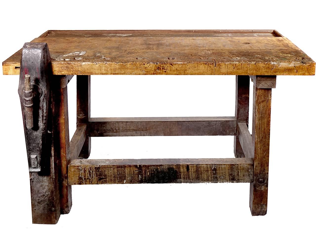 This is a nice weathered carpenter’s workbench with a rustic finish. The patina shows a well used top with 100 years of work. It has an interesting long vertical vise or clamp and square holes for bench dogs. The look and size are just right.

 