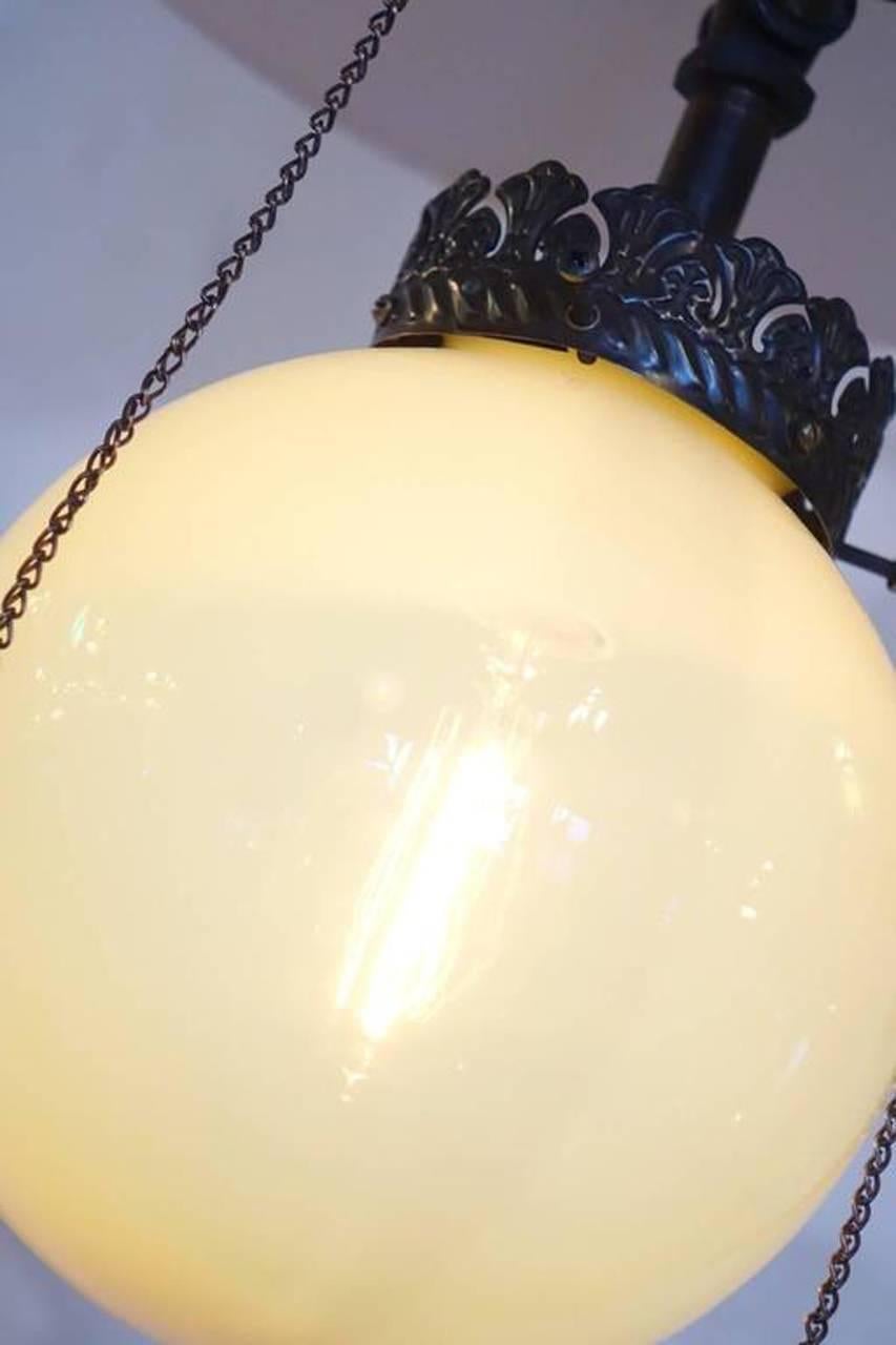 This early gas lamp has an 8 inch Vaseline glass globe, 16 inch porcelain shade and original black or copper japanned finish. It has been rewired to take a standard bulb. This is the type of lighting used in early general stores in the 1800s.