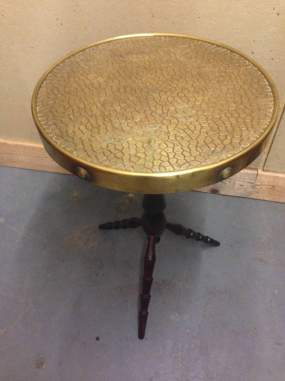 German expressionist side table inspired by Constantin Brâncuși. The hammered brass top on a turned three leg base.