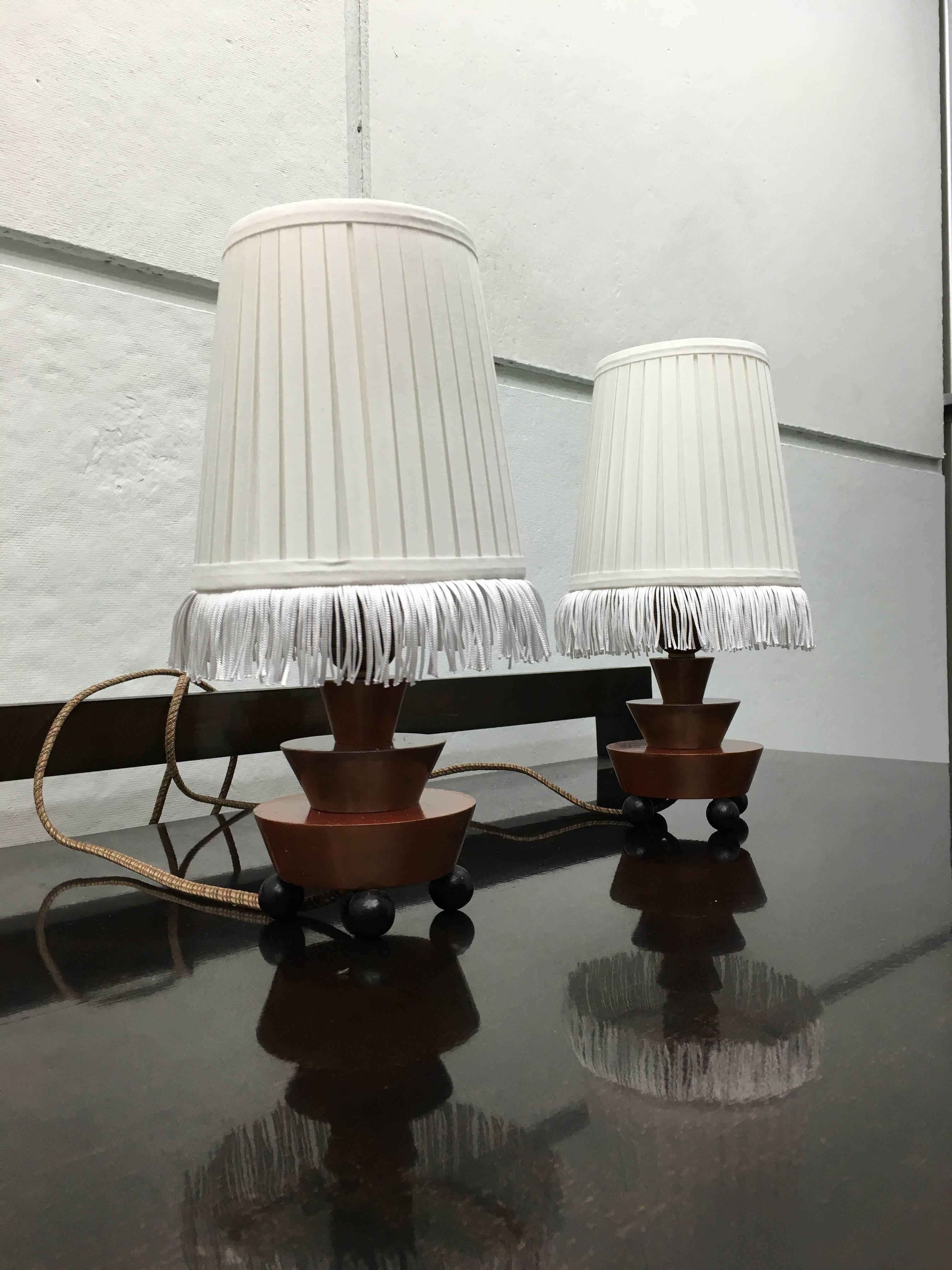 A pair of German Art Deco table lamps of expressionist design. The brass socket mounted on a lacquered wooden base.