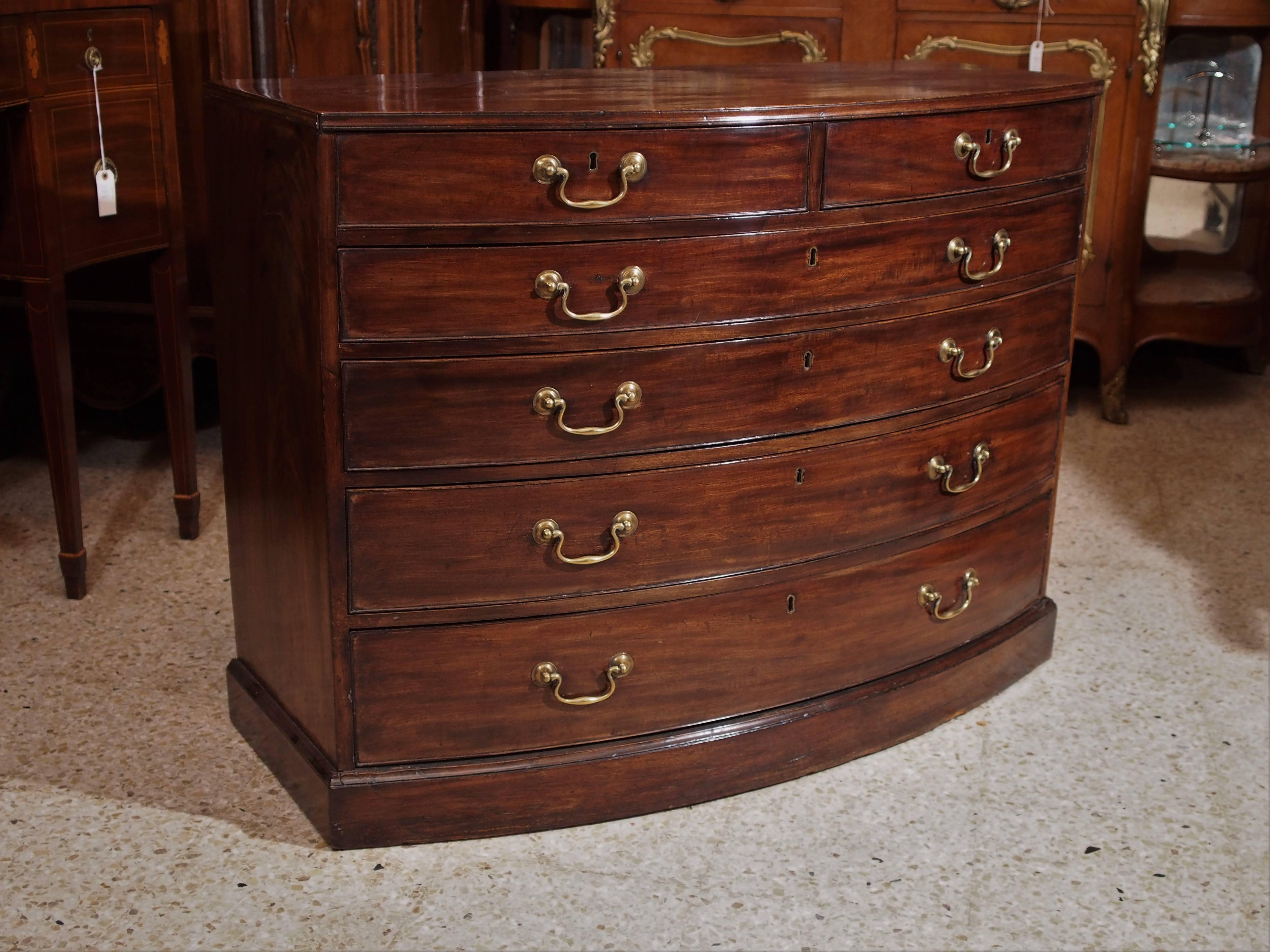 This handsome bow front chest is sold and very appealing. The shape of the drawers follow the lines of the front. This practical piece of antique furniture has four full bottom drawers, with the top drawer split in two.
