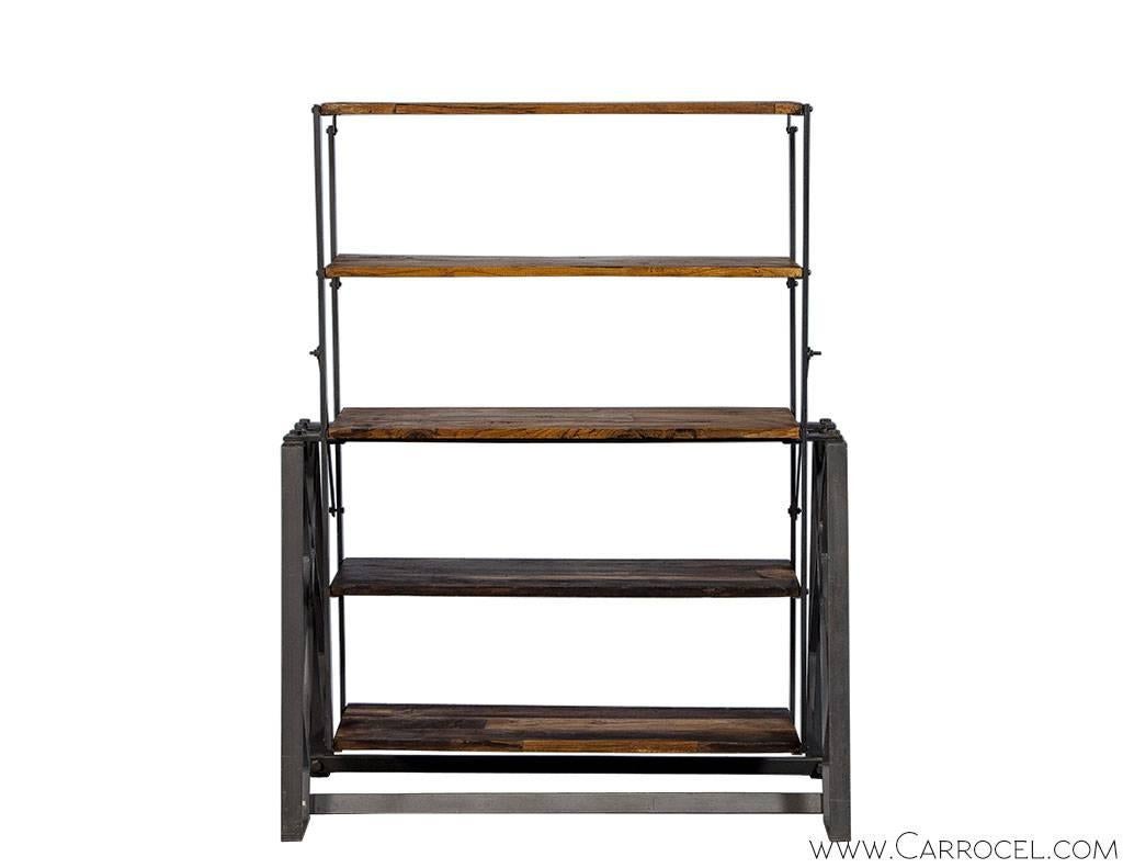 Interesting and rustic this display shelf brings a industrial characters. Five reclaimed wood shelves contrast a steel grey iron frame that allows the shelves to pivot offering versatility in its function and display – from straight up and down, to
