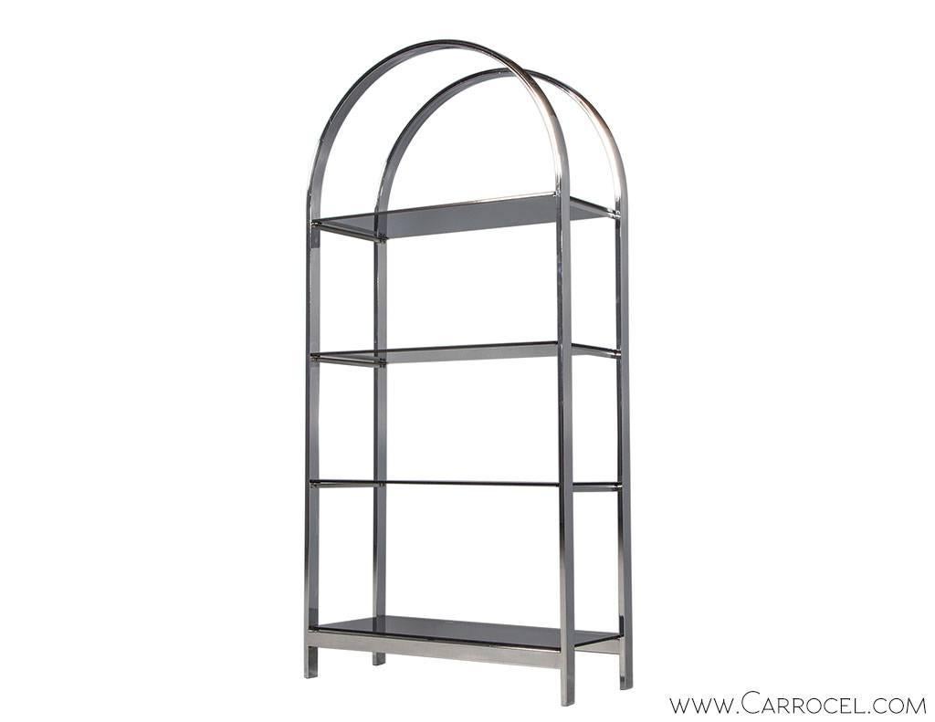 This arched polished chrome étagère is a gorgeous sampling of mid century design in the style of Milo Baughman. Five black glass shelves are secured in the frame offering display space, visible from both sides providing a great room divider. A