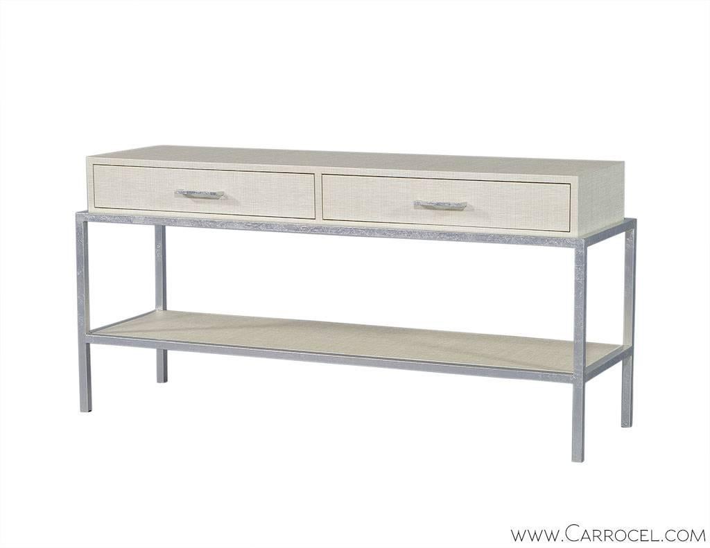 From the American furniture company EJ Victor, comes this elegant and stunning console table. Wrapped in linen and sealed with an iridescent icicle finish this piece has a light natural presence. The top is constructed with two drawers over a lower