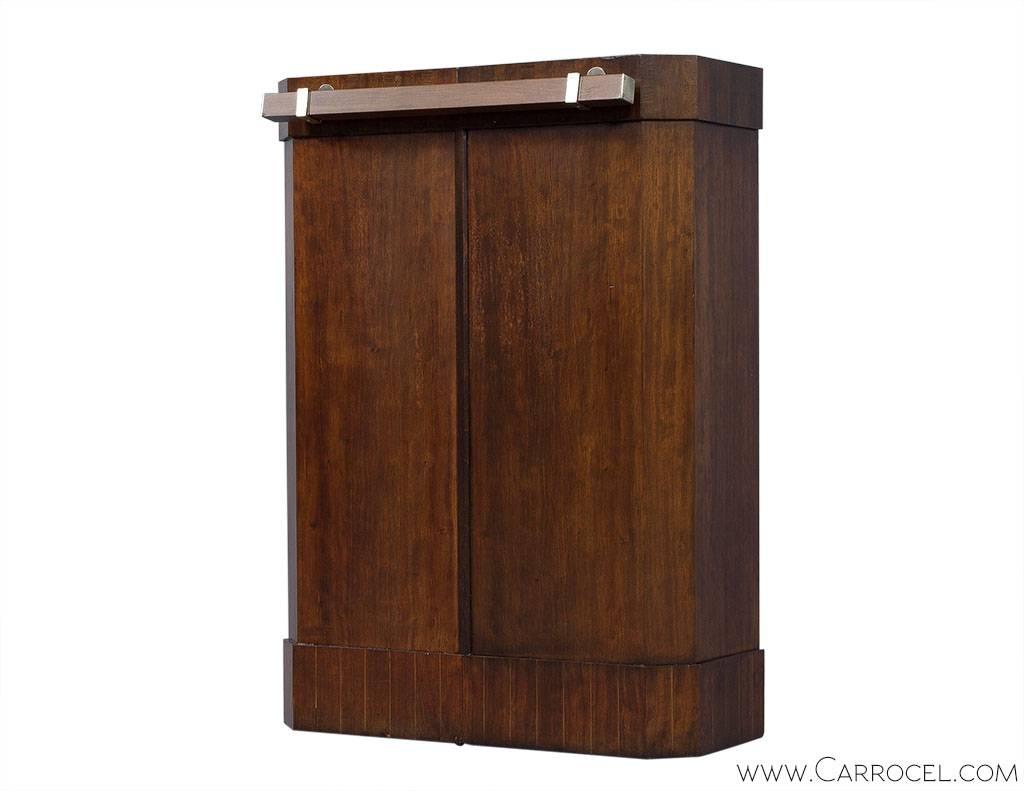 A great concept for a unique bar, this cabinet opens revealing an interior outfitted for bottles, glasses and bar tools. The cabinet has a gorgeous wood grain. Minor restoration has been performed to bring this piece to original beauty.