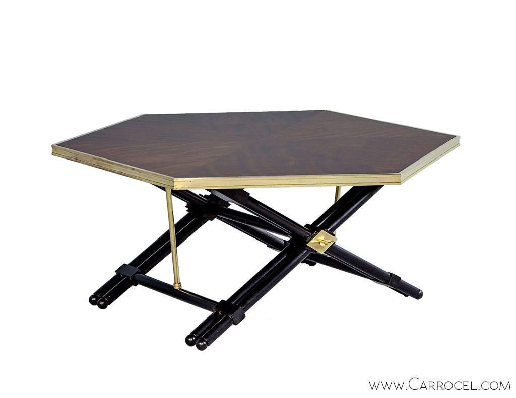 Stunning vintage cocktail table restored with a modern sensibility. The top consists of unique mahogany veneers finished to show the depth and variation of the grain and is trimmed in bright polished brass. The table rests on an ebonized x-base with