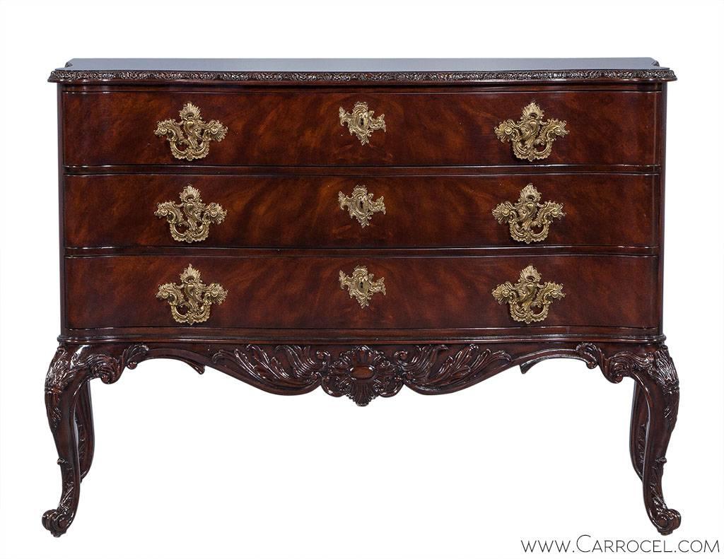 This beautiful and ornate three-drawer George III chest showcases intricately hand-carved cabriole legs and moldings along with Rococo style drawer pulls. Mahogany and brass in color, this chest can easily become the centerpiece of any bedroom.