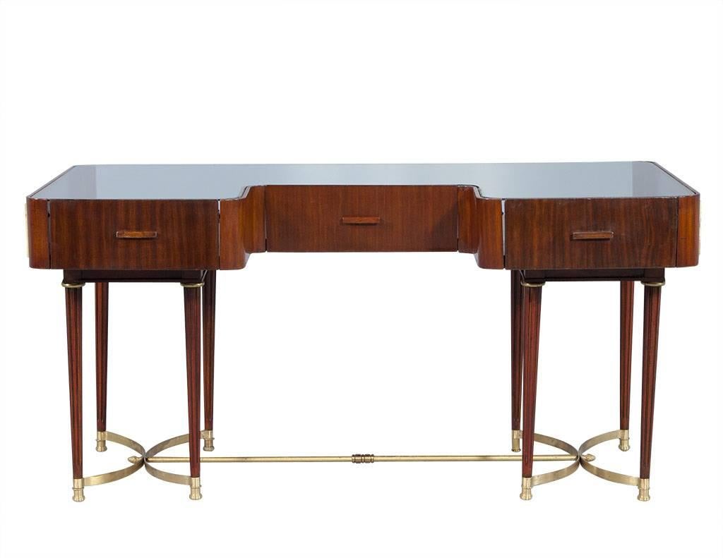 Stunning Louis XVI style display table. Decorated with a Greek key motif around the sides. Three drop doors across the front provide access to the display area. Original glass top, turned fluted legs connected by a decorative brass stretcher.

Price