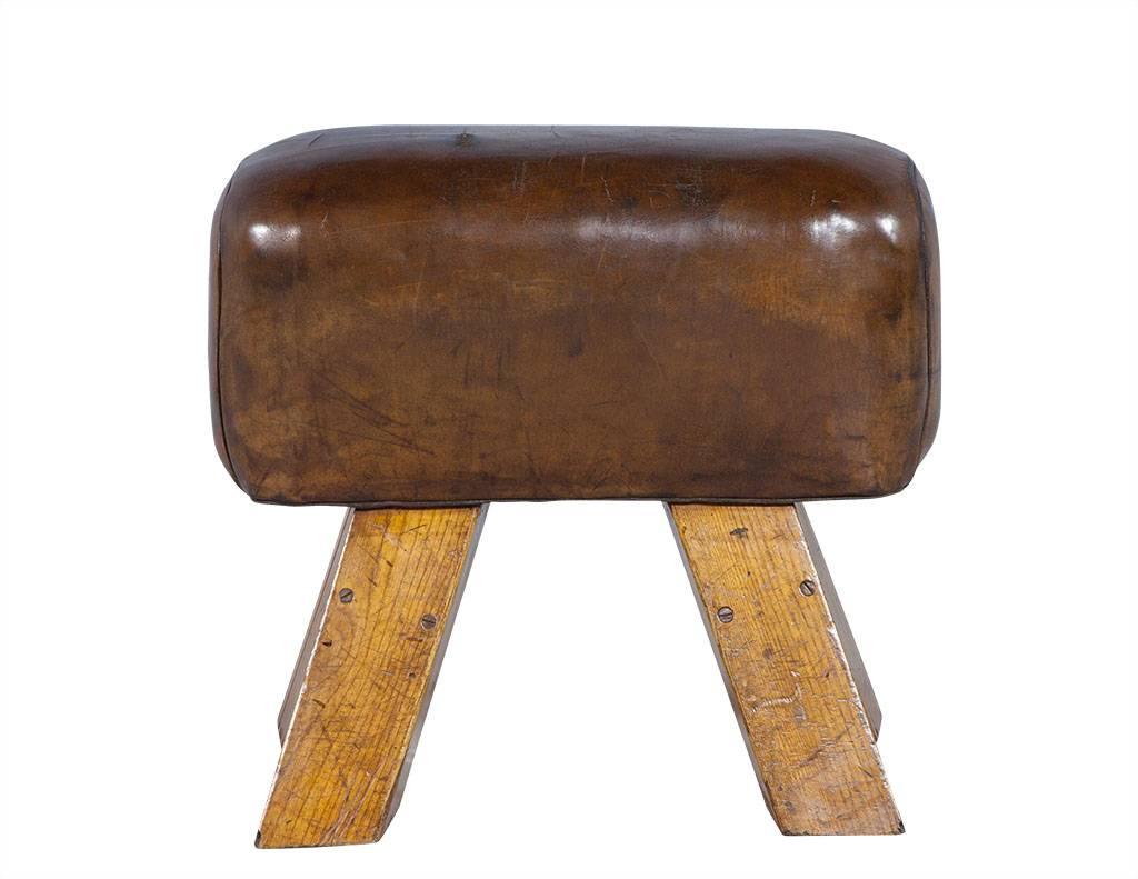 Gorgeous antique pommel horse, made in the early 1900s. The piece is in sturdy original condition. The leather has a glowing patina and is naturally distressed from time and wear. Mounted on four block legs.