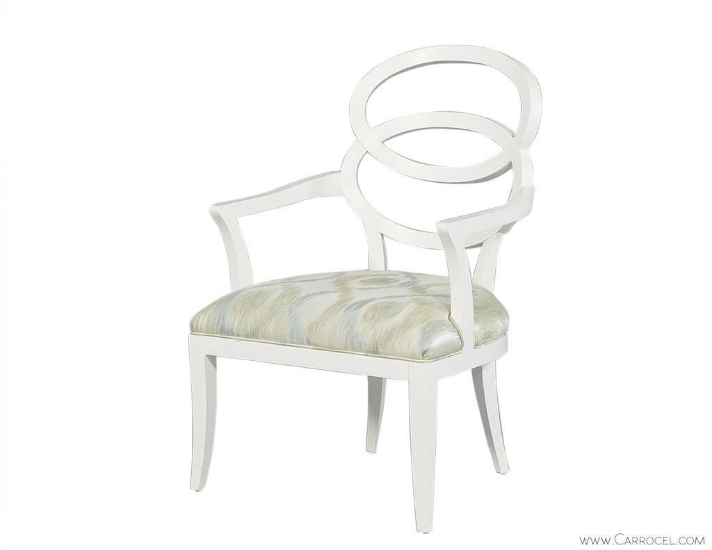 Gorgeous pair of bracelet back chairs fashioned to boast a light soft feminine feel while having a quality crafted frame. Finished in satin white and upholstered in pastel shimmering green fabric the elegance of this pair will effortlessly light up