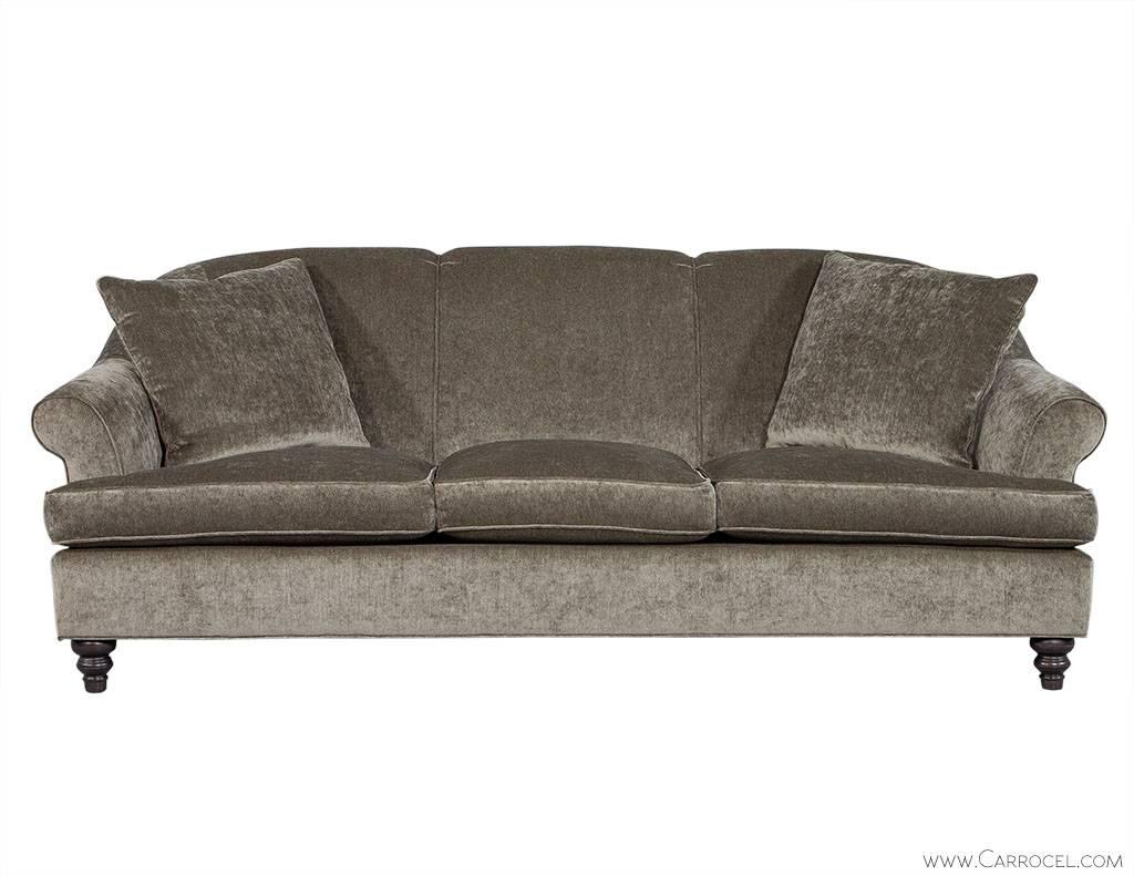 This luxurious sofa sits atop dark espresso turned maple legs. It boasts down envelop cushions and is wrapped in super soft grey Chenille upholstery. The rolled arms offer support and lend an inviting shape, while two plush toss cushions are