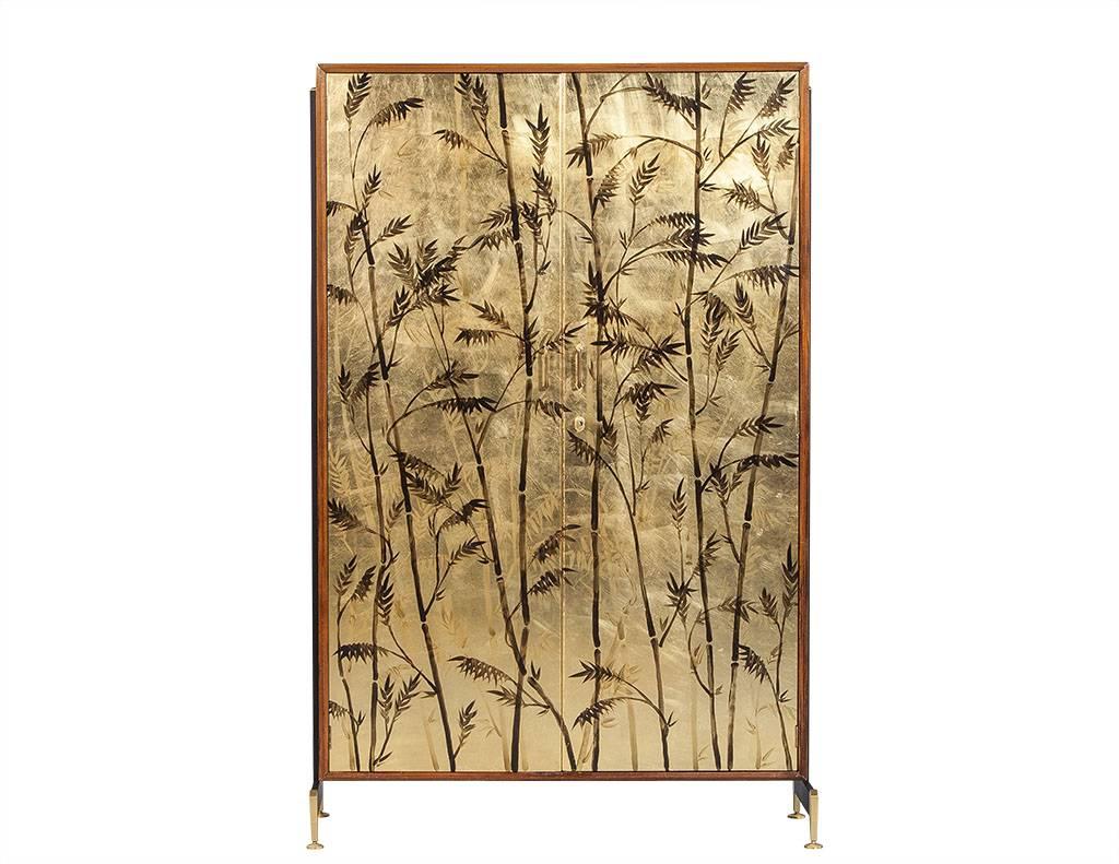 This Antonio Ferreti armoire is a true showstopper! The front is adorned with a gold leaf façade, complete with illustrated black bamboo shoots. The interior is divided into compartments for storage on the right, with a clothes bar to the left. The