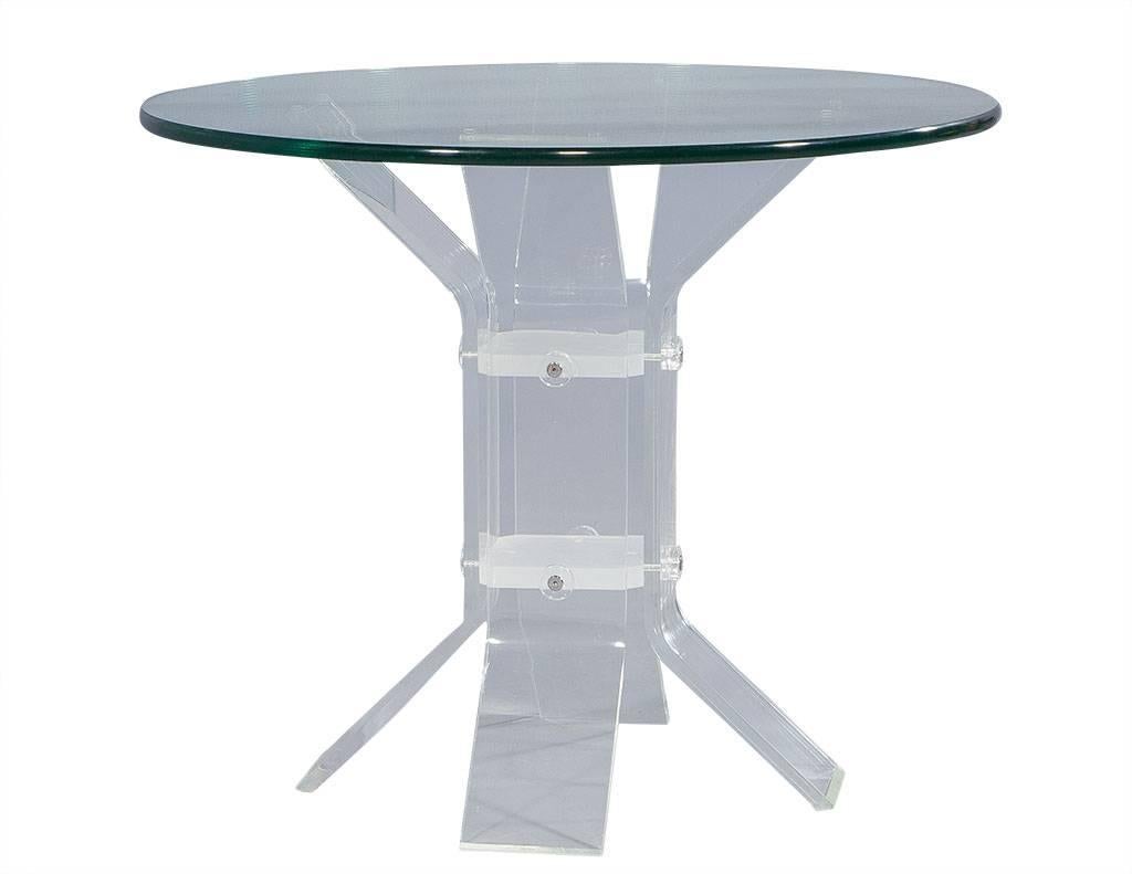 An 1980s Classic! This sharp occasional table has a thick, round glass top and sits upon a Lucite center pedestal. The pedestal is equipped with four arms at the top and four legs at the bottom that angle outwards and are supported by frosted