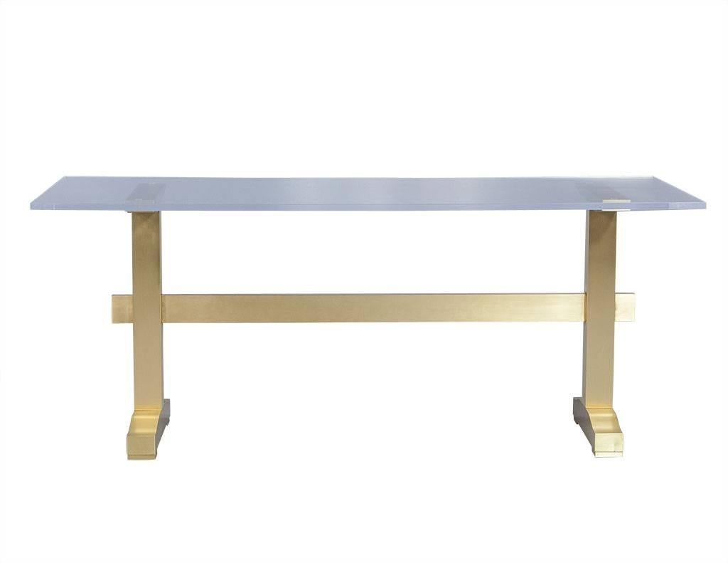 Beautiful modern piece that can be used as a desk or a small dining table. Constructed with a solid H-frame brushed brass base and thick acrylic top. An addition of luxury to any home.