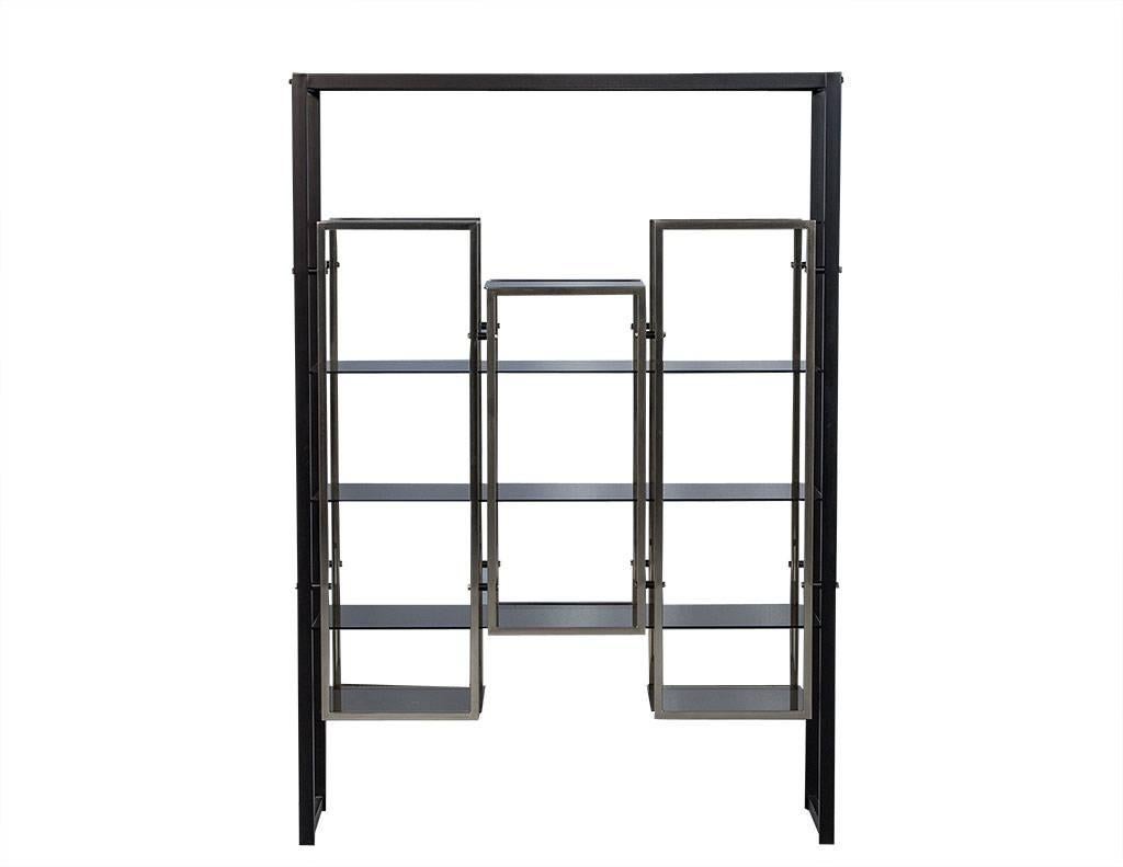 This striking etagere is fashioned out of a matte black metal frame with a chrome shelving unit comprised of three floating compartments with smoked glass shelves. This piece is unique and modern and the perfect addition to a French style living