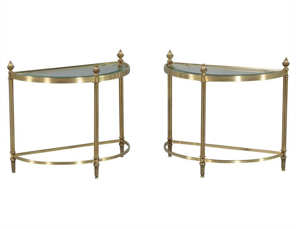 This three-piece classic Maison Jansen cocktail table boasts a brass frame and fluted legs with decorative finials on top. Below stretchers reach to the center meeting in two opposing curves adorned by another finial. The beveled edge glass tops